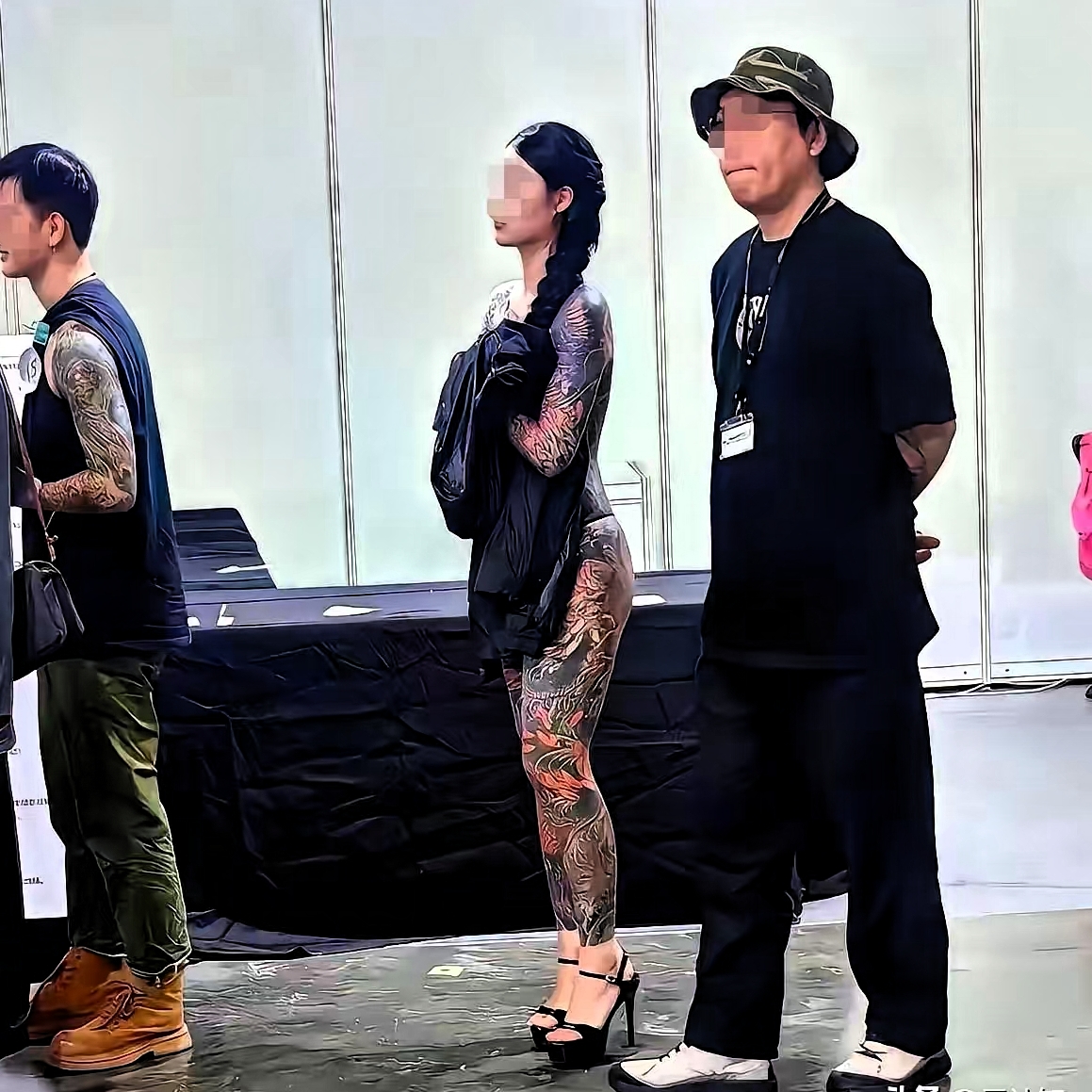 看横幅上写着“纹身艺术节”。男男女女纹身爱好者们带着“皮肤艺术”粉墨登...