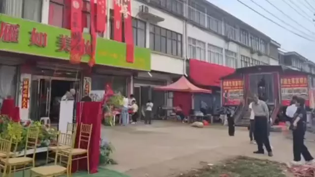 江苏一殡葬店停业两天遮招牌，邻居结婚这事他看得比生意重

江苏一殡葬店为邻居婚礼让路，红毯遮招牌、停业两天。店主与新娘爷爷平辈，一句“女孩子结婚是人生大事”，把黑底白字的招牌盖得严严实实。这事乍看是邻里温情，细想却藏着更耐人寻味的命题：当“晦气”与“喜气”狭路相逢，我们究竟在避讳什么？

殡葬店，卖