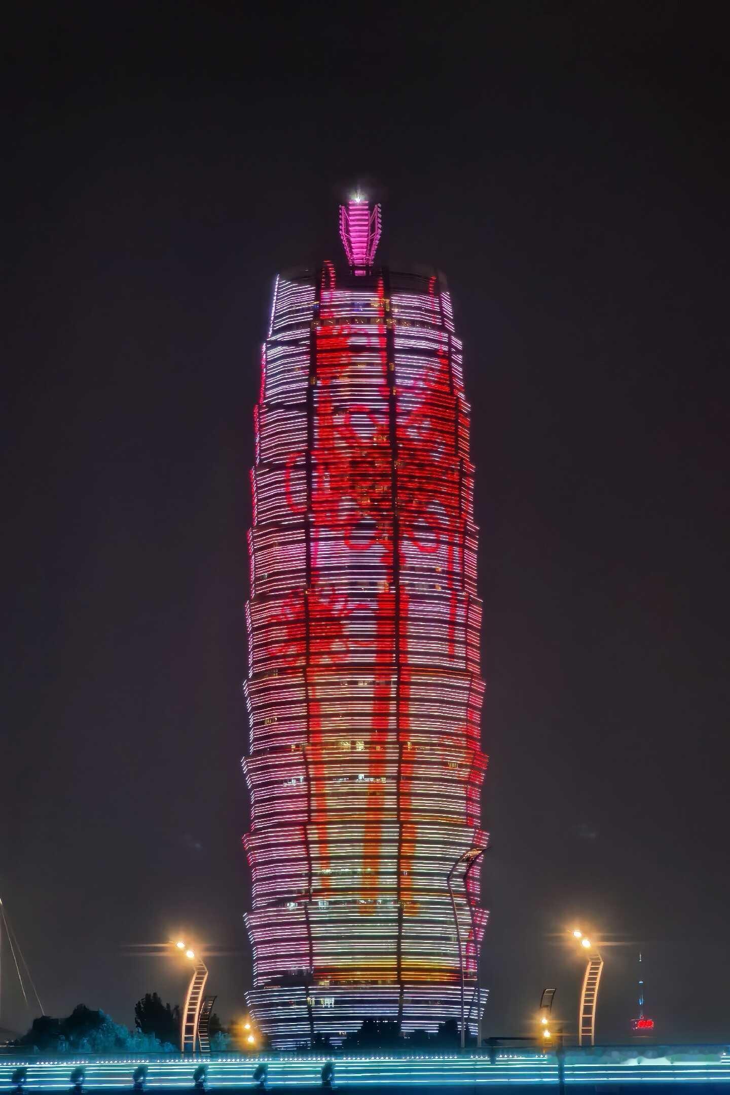来郑州一定要看的地标夜景，千禧广场大玉米。
漆黑夜幕之下，整栋楼宇被绚丽灯光包裹，红粉流光在楼体流转，大气又耀眼。独特的塔楼造型，配上流动的光影，氛围感直接拉满。
 
桥下灯带与路边路灯相互呼应，城市的繁华在此刻尽数展现。静静站在远处观赏，感受独