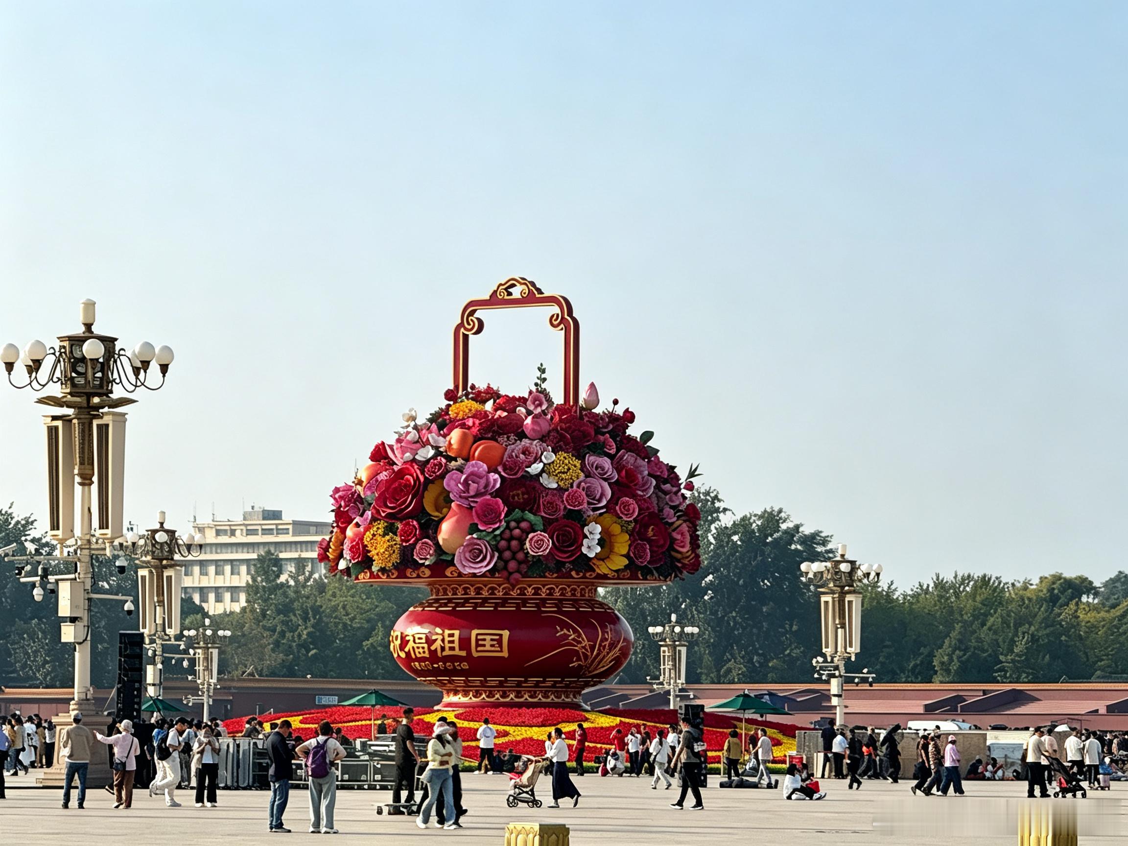 天安门广场，巨型“祝福祖国”大花篮巍然矗立。
篮中汇集十二月花：梅、杏、桃、芍药、石榴花、荷花、蜀葵、桂花、菊花、木芙蓉、山茶、水仙，辅以牡丹、月季、向日葵，百花盛放，寓意四季锦绣。
寿桃、苹果、柿子、石榴、葡萄五种硕果点缀其中：寿桃祈愿福寿绵长，苹果寄寓平安，柿子事事如意，石榴象 ​