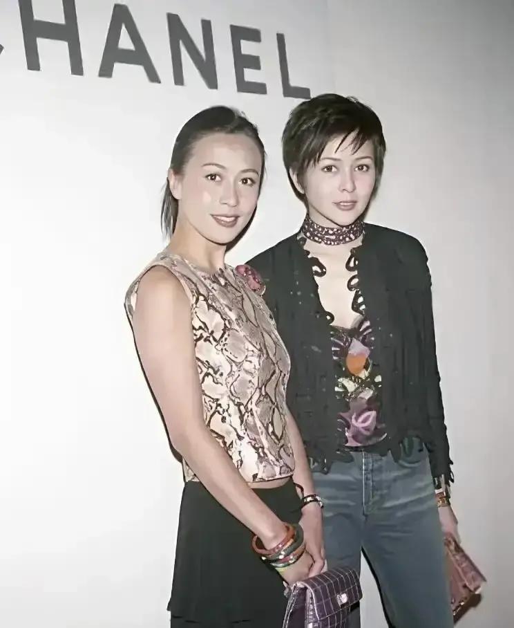 当年要是没有关之琳在大门口那句冷脸回怼，刘嘉玲恐怕当场就得被媒体生吞活剥了。
那是1988年的一场慈善晚宴，散场时门口全是抓拍的记者。
合影那几秒钟，关之琳习惯性站正中，刘嘉玲很自然退了半步在侧后方。
有个没眼力见的镜头对着刘嘉玲大喊，说她站后面比关姐矮了一截，让她往前挪。
刘嘉玲脸上还挂着