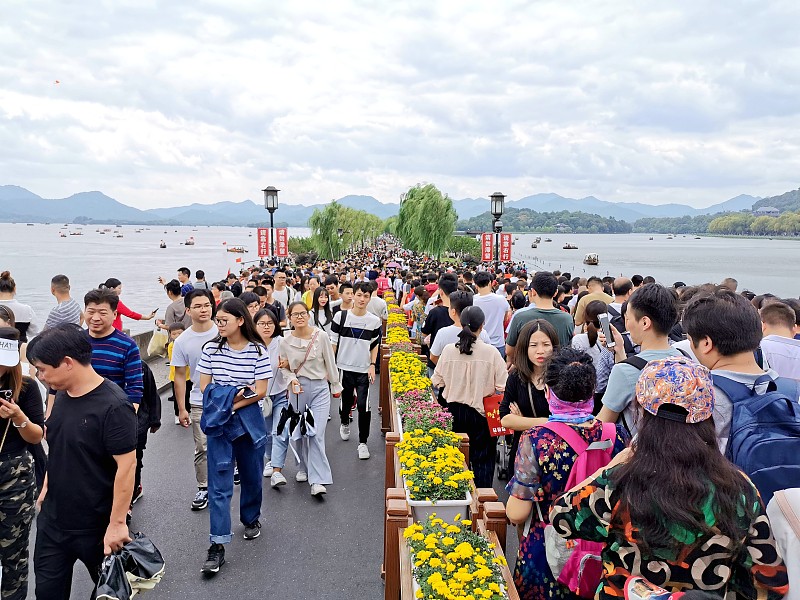 国庆假期第二天，杭州西湖断桥再次被挤得水泄不通。放眼望去，桥上密密麻麻全是人头，有人打趣说，断桥没断，倒是快被人潮压断了。这样的场面，年年上演，可大伙儿还是心甘情愿地往里挤，图的是什么呢？
清晨的西湖，本该是一幅水墨画。薄雾缠绕，柳枝轻摆，雷峰塔静静立在湖边。可到了上午十点，画风突变。断桥两侧，游客