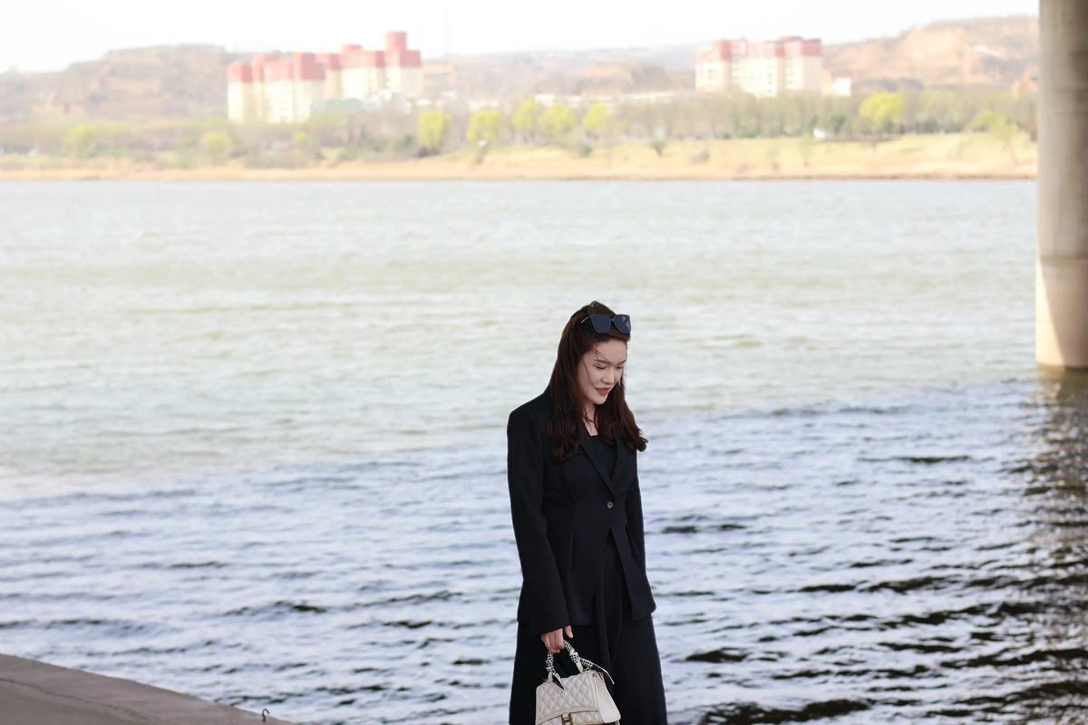 都市时尚女郎，河畔漫步，黑西装搭配白手袋，尽显优雅风范。，金钱健康哪个重要