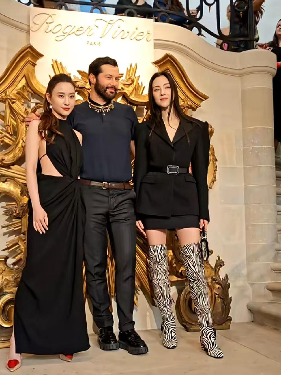 35 岁何超莲和 29 岁娜然同框，一个是豪门女儿，一个是豪门准儿媳。

何超莲是赌王女儿，是赌王的三太所生，只见她一身黑挖空长裙，腰侧露肉白得晃眼，脚踩红尖头鞋，站得笔直表情淡定，完全是从小见惯大场面的样子。

娜然更猛，黑西装短裙配斑马纹过膝靴，腿又细又直，长直发披肩冷着脸，气场直接压全场。就是