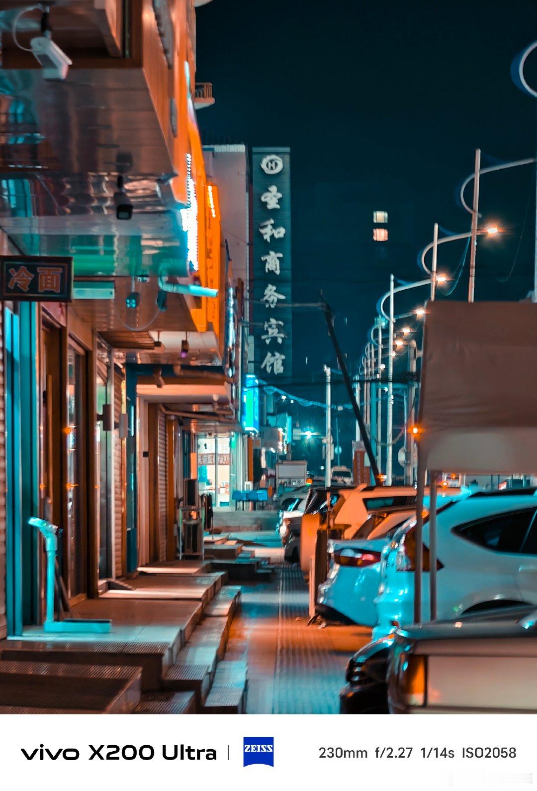 #vivo[超话]# 小镇夜晚的街巷，暖黄路灯搭配青蓝夜色，街边招牌静静伫立。vivo X200 Ultra长焦镜头，捕捉这份小城独有的烟火氛围感，平凡夜景，藏着温柔人间。#vivo超话# ​