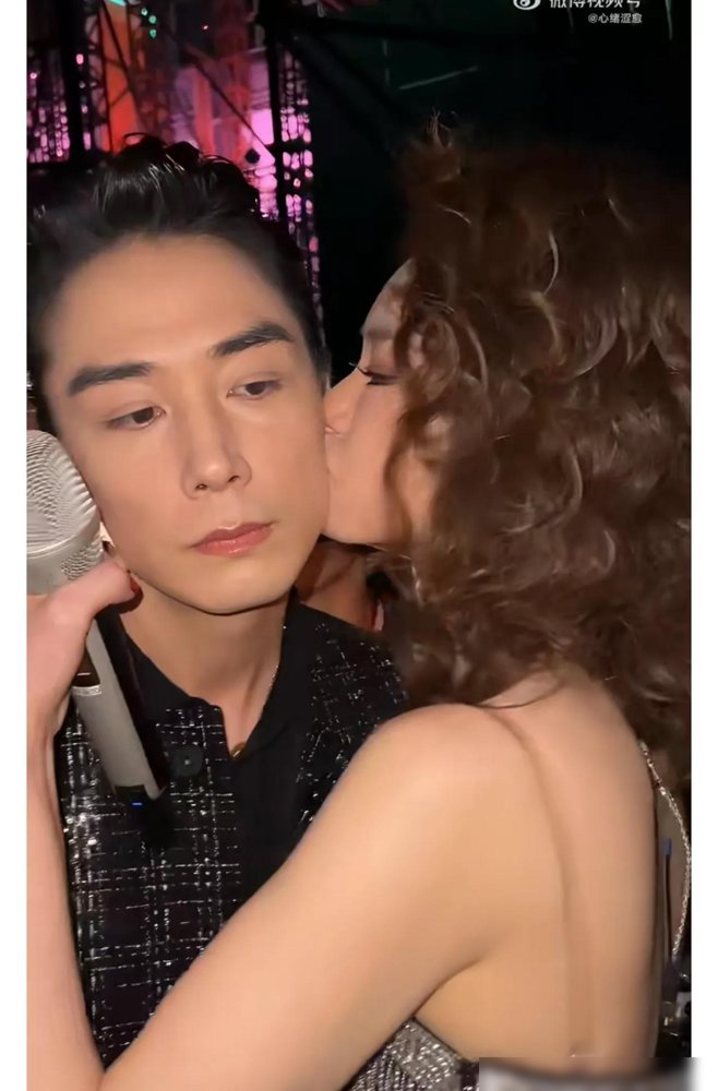 李承铉脸上顶着一个口红印就上台了，戚薇亲的，当着一群工作人员的面。
结婚这么多年，这俩人还搞这种小动作。不是摆拍，是临上台前戚薇突然拉他，踮脚就在左脸盖了个戳。李承铉没擦，就那么带着上台了。
你看戚薇平时多硬的人，穿32斤的裙子走不了路，坐平板车被推上红毯，眉头打针打僵了也敢直播承认。唯独在李承