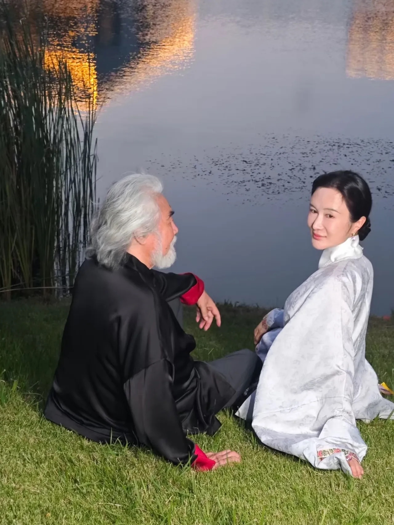 75岁张纪中携娇妻杜星霖现身无锡，湖畔草地闲坐，光影温柔。张导虽银发白须，但精神矍铄；44岁的杜星霖一袭素白古装，温婉依旧，夫妻同框颇有古风意境。

此行实为故地重游，张纪中曾深度参与无锡三国水浒城建设，拍过《水浒传》等经典。如今他家庭美满幸福，虽近年常因直播、备孕五胎引热议，但岁月似乎未减其气场。