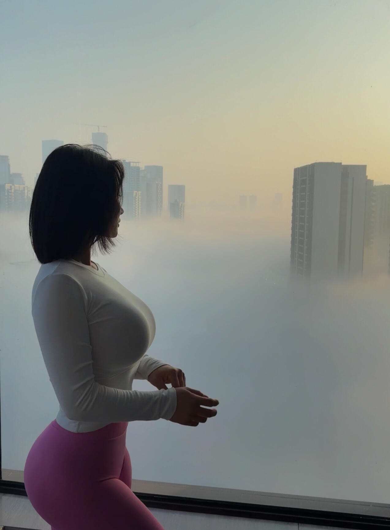 晨光中的城市剪影，加上这位瑜伽女神的倩影，简直是绝配！她穿着白色上衣和...