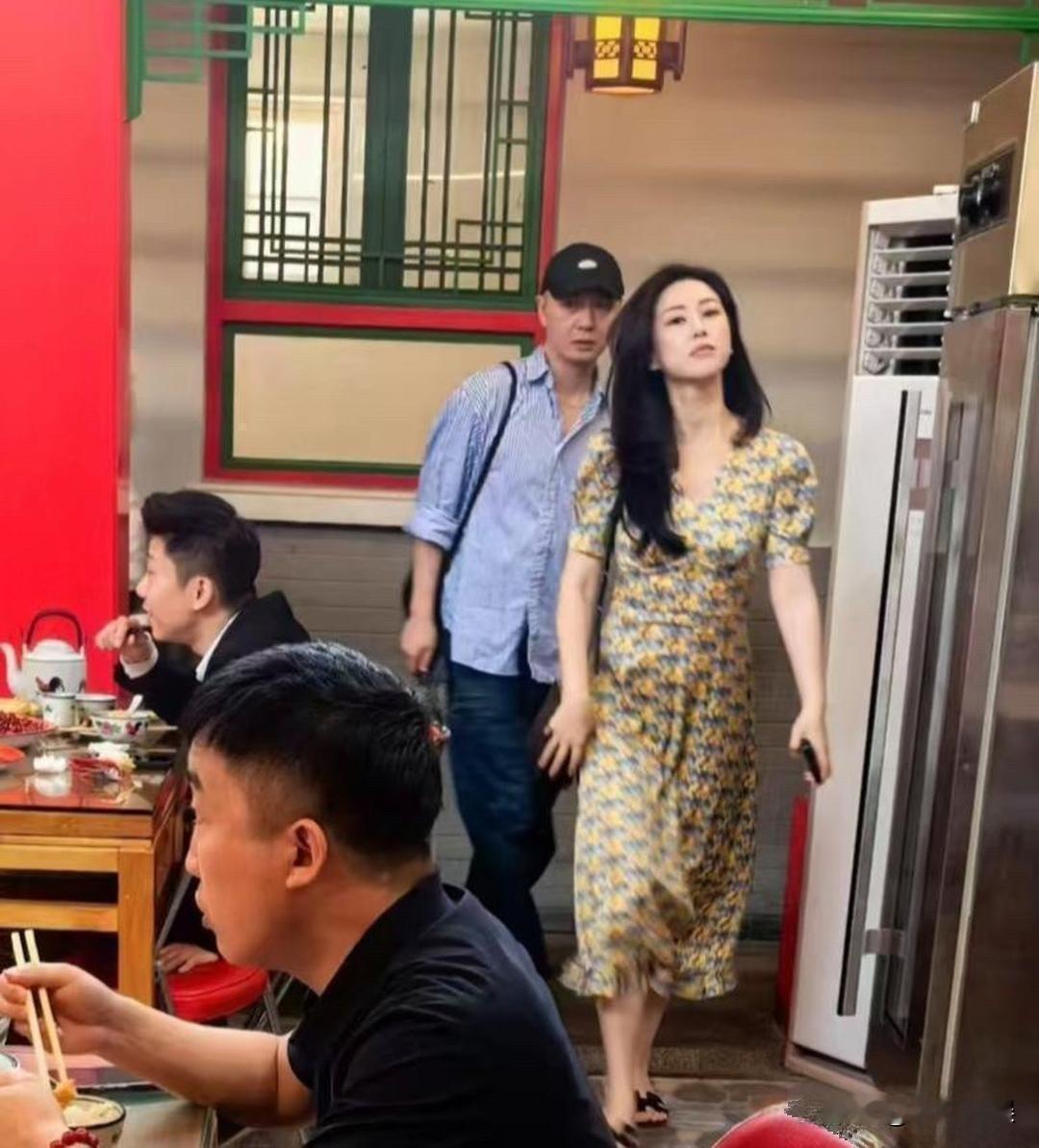 朱珠在中式餐馆内被路人偶遇。她身穿黄调碎花连衣裙，一头乌黑长卷发氛围感十足。即便是日常出行，气质依旧明艳大方，在人群里格外惹眼。