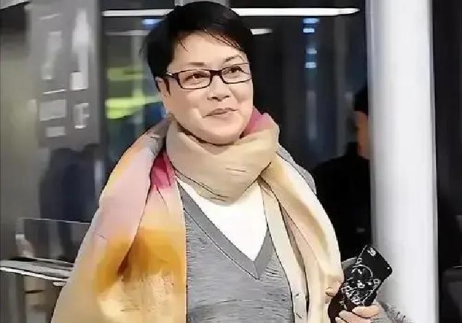 63岁毛阿敏机场白发不染，放弃260亿躲过4200亿窟窿，21岁女儿在美国学艺术儿子要当体育老师
2026年春天，北京首都机场。一个穿着黑T恤牛仔裤的女人推着行李箱走出来，黄头发里夹着大片白丝，没有助理，没有保镖。有人认出她，举起手机，她笑了笑，摆摆手，继续往出口走。
这是毛阿敏。上一次她以这种“不