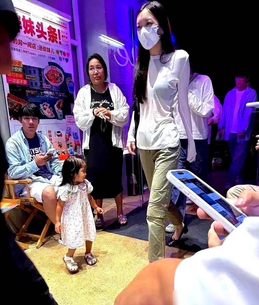 王菲跟李嫣同框，又被骂了。说母女俩全程零交流，王菲只顾自己走，李嫣低头刷手机，中间隔着一道缝。
有人截了图，配文“最熟悉的陌生人”。
可你看看上个月阿那亚音乐节，王菲带着李嫣挤在前排，给窦靖童挥手。李嫣刚满20，身高175，穿着黑T恤往那一站，跟她妈一个模子刻出来的。
亲妈不亲，能大半夜陪着去