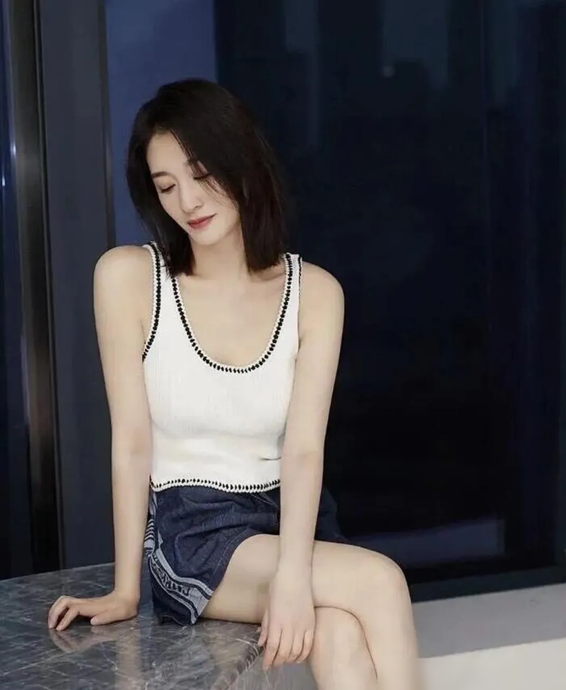 谁能想到，一件随处可见的白背心，直接撕下了内娱女星精修图的遮羞布。
《乘风2026》录制现场，49岁的李小冉没借高定礼服，没搞全包眼线。
就一件最基础的白背心，套条牛仔裤，扎个丸子头大步流星。原相机怼脸直拍下，皮肤白到发光，连一丝疲态都抓不着。
别的女星拼命往身上堆奢侈品，用八百层滤镜掩盖岁月