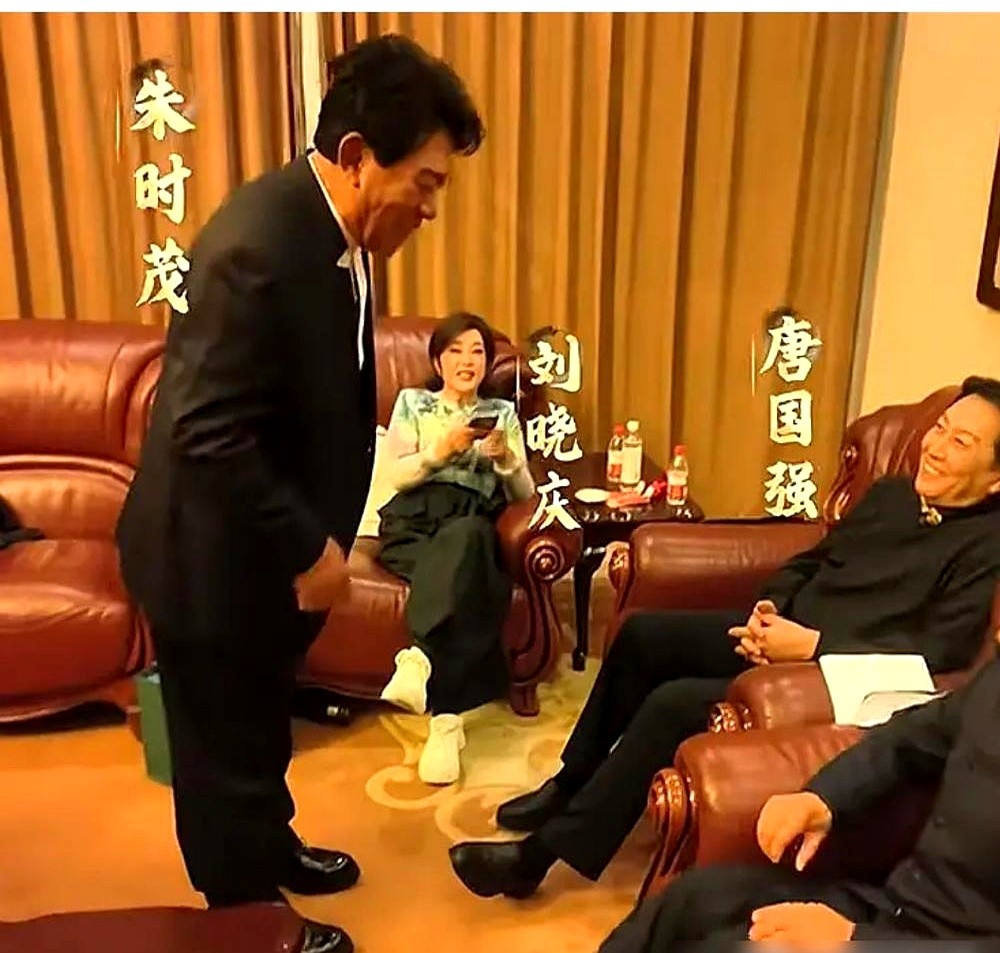 合影里，朱时茂双手交叠躬着身子，旁边坐着的刘晓庆翘着二郎腿连眼皮都没抬，唐国强架子端得四平八稳。

不知道的还以为后辈在给大腕汇报工作。

可论资历谁虚谁啊？全是八一厂出来的老人。《小花》红了唐国强刘晓庆，朱时茂转头就凭《牧马人》成了国民记忆，私下几十年的交情。

谁能想到2026年，这三位都在短剧