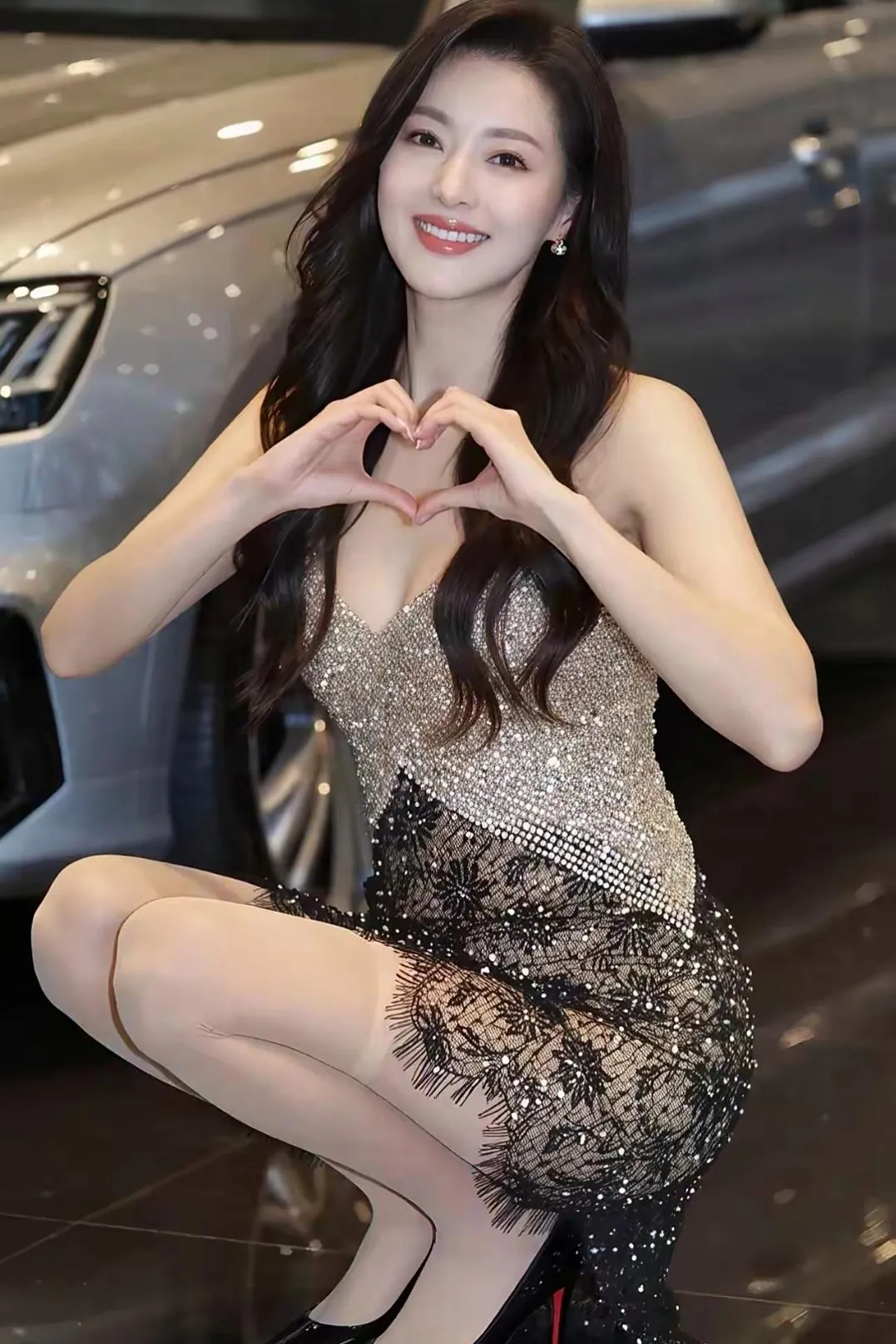 在车展现场，优雅的车模小姐姐，以甜美的笑容和灵动的姿态，为展车增添了别...