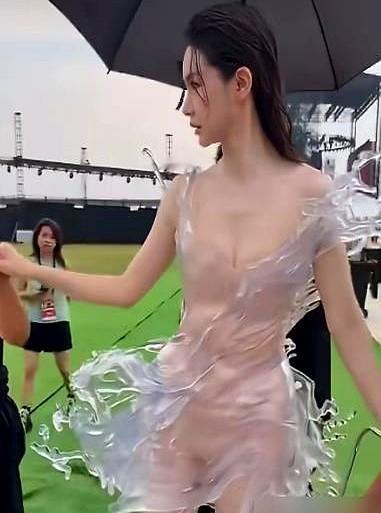 李雪琴硬着头皮上台替人领奖，台下那位正主正被32斤的“塑料外壳”死死封印在原地。

这场红毯走得像搬运重物。五个工作人员把这件3D打印的水花裙抬进场，用推车把戚薇弄进去。裙子又硬又透，迈不开腿也弯不了腰。

当天她刚做完根管治疗，脸还肿着，就这么硬扛着几十斤的重量站桩。到了领奖环节，裙子卡住根本没法