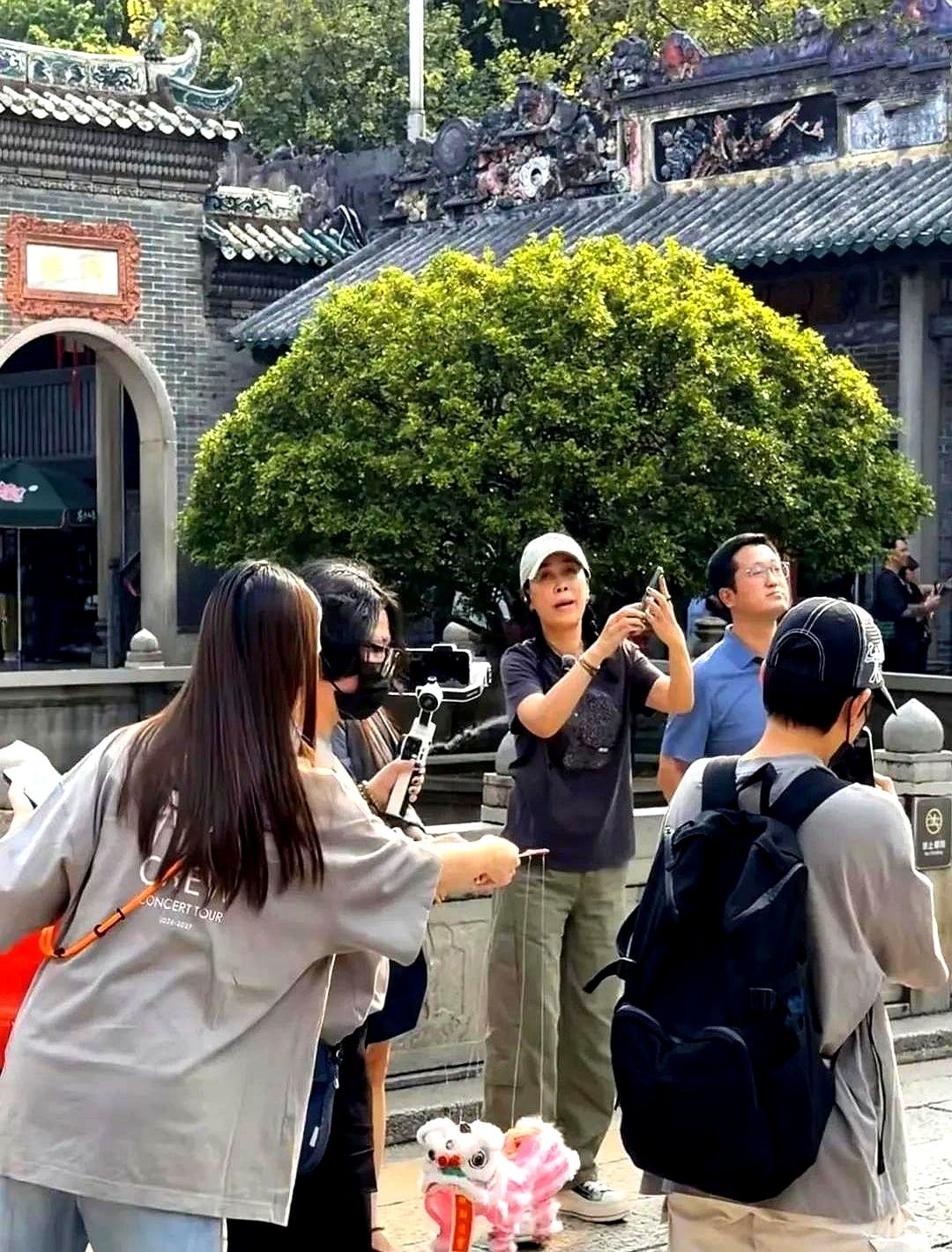 快六十岁的那英扎麻花辫逛佛山祖庙，生图状态居然像三十多岁。

穿得松松垮垮，个子高挑，在庙里闲逛的松弛样，跟舞台上吼《征服》判若两人。她这次去佛山开演唱会，门票一开卖就抢空，号召力依然硬核。

身边普通人五十出头就一脸疲态，女明星维持这状态背后肯定没少砸钱。但讲真，没有天生好骨相撑着，光靠钱真能堆出