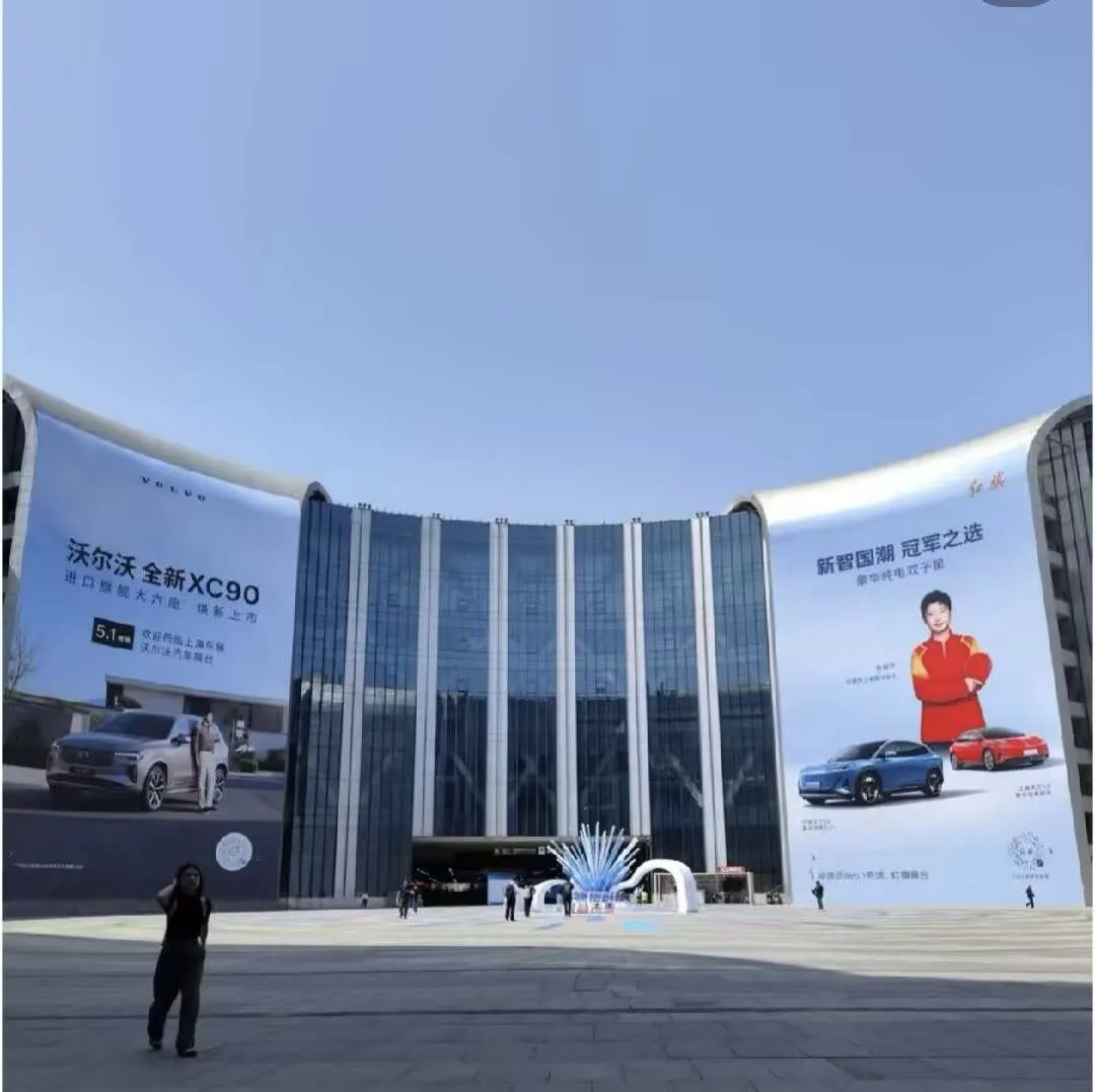 友商展示的是车，红旗展示的是莎莎。  看这广告墙，一边沃尔沃展示新车...