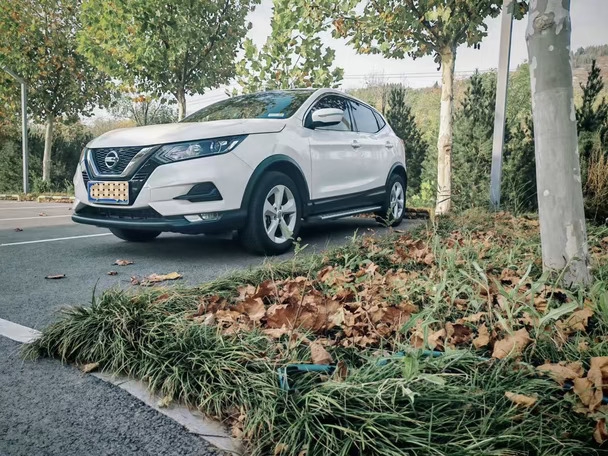 秋日光影正好，开着日产逍客奔赴郊外，寻一处铺满落叶的路边停车。柔和阳光洒在车身上，随手一拍氛围感拉满