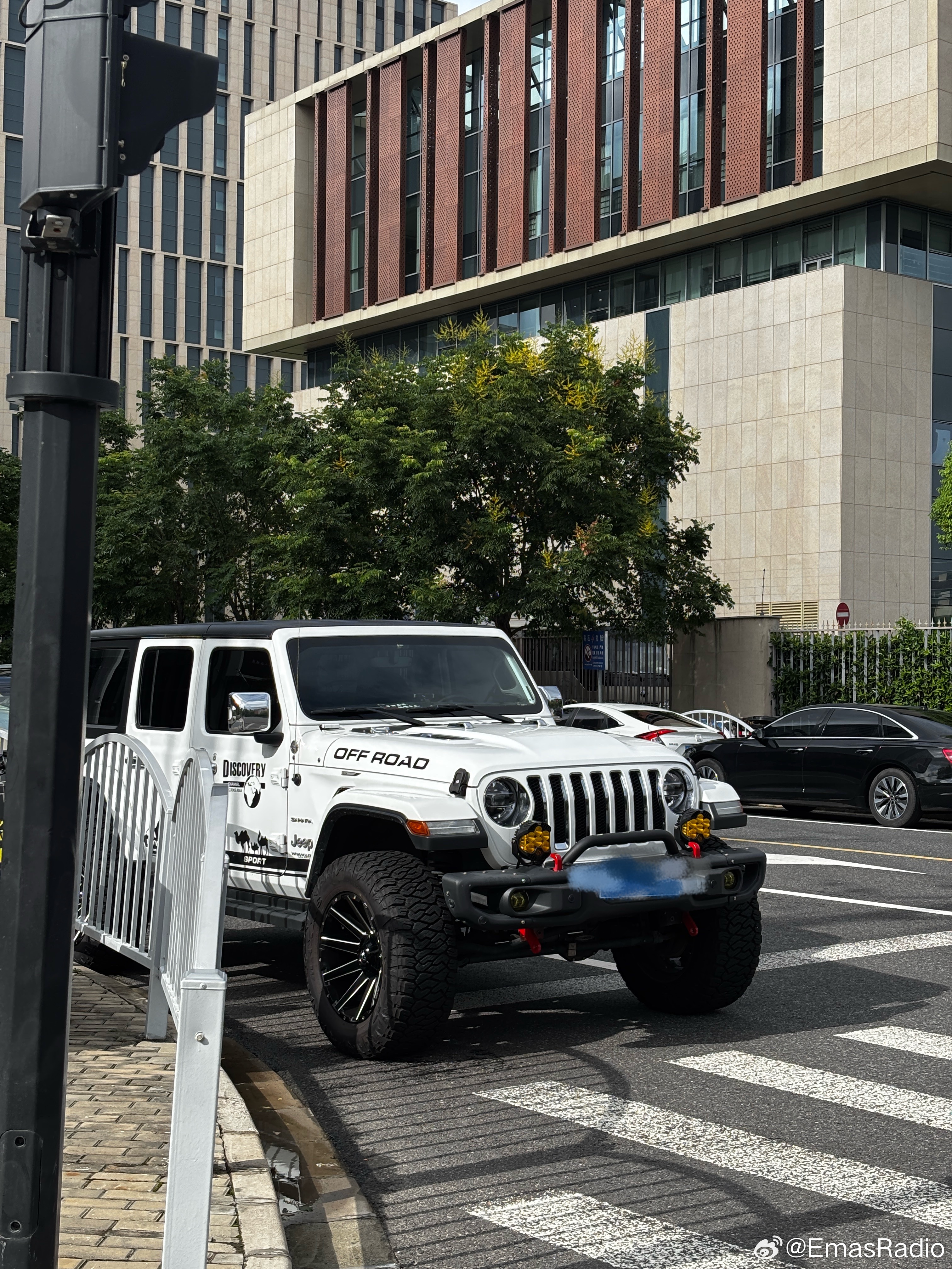 路上看到一台很典型的美式Off-road Jeep，这个黑白撞色和加大越野胎太抓人了！

这类车在美国有非常成熟的改装文化，尤其是4✖️4、Overlanding和SEMA文化。升高底盘、加大越野胎、强化前杠、绞盘，这些都不是单纯为了“好看”，核心其实都是为了提升车辆的接近角、离去角、离地间隙和越野脱困能力。

 ​
