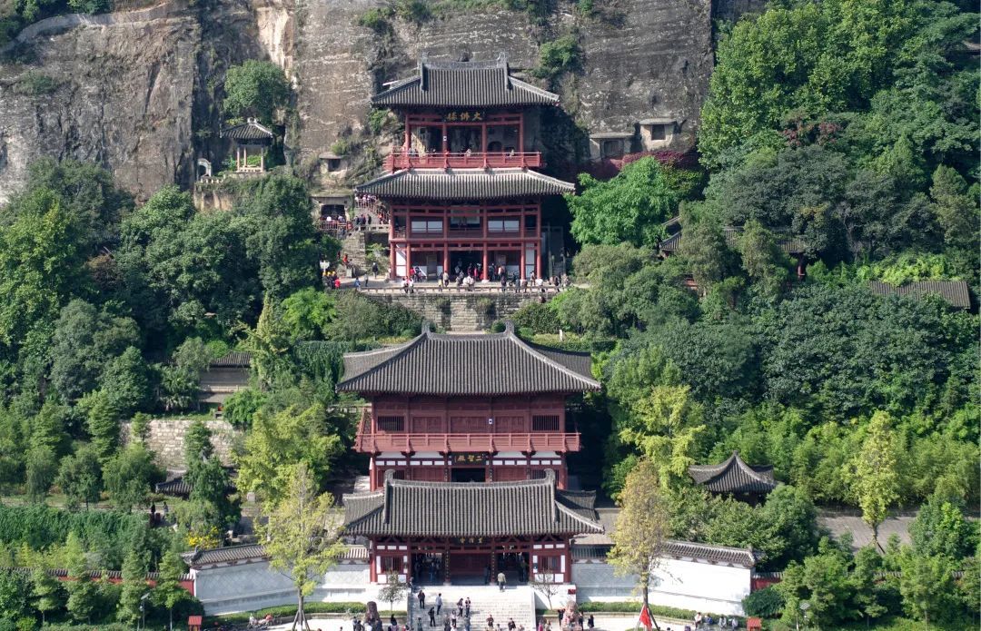 今天来到四川广元，探访皇泽寺。古寺背靠乌龙山，面朝嘉陵江，红墙古木，江风徐徐。走进则天殿，看见武后石刻真容，崖壁上的摩崖石刻静静伫立，藏着千年故事。
 
一路游览，能感受到这座城市对女皇文化的用心打造。城市各处都有相关文化符号，节庆、文创、景观配套齐全，把这段历史变成了可触摸的