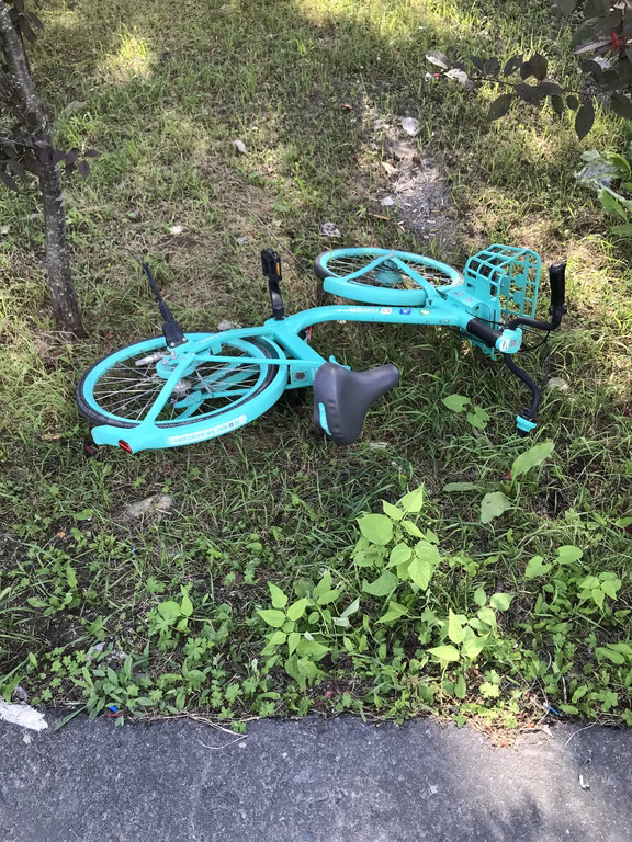 被人故意丢弃到旮旯角落的共享单车