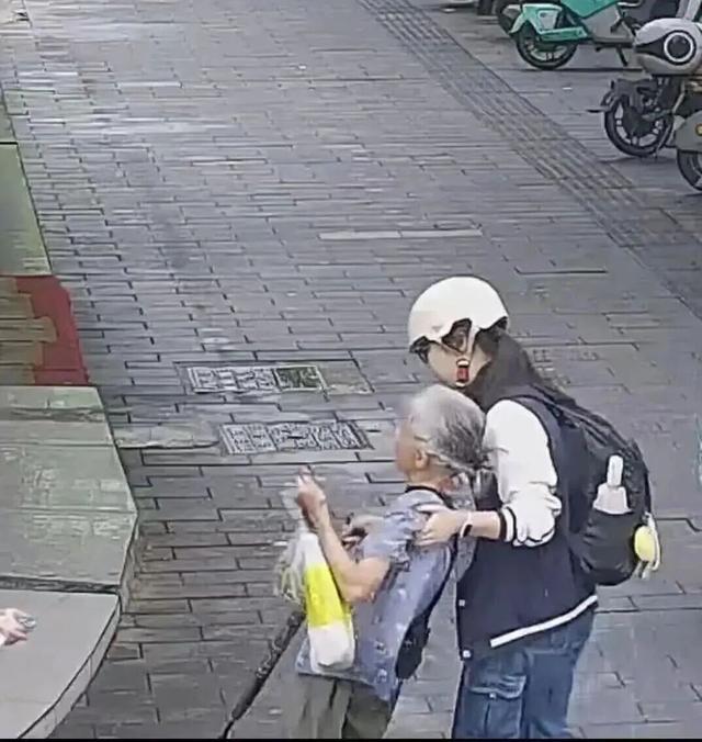 十七岁的周子歆，那天早晨和往常一样骑车去上学，路上撞见一位白发老人摔倒在地，后脑勺渗出血来。街上来来往往的人不少，有人停下看了一眼，有人绕开走了。她没想太多，把车一停，蹲下身去。

没有专业急救经验，能做的就是最朴素的事。脱下自己的校服，叠一叠，按在老人流血的伤口上，压住。血渗出来，染红了衣服的布料