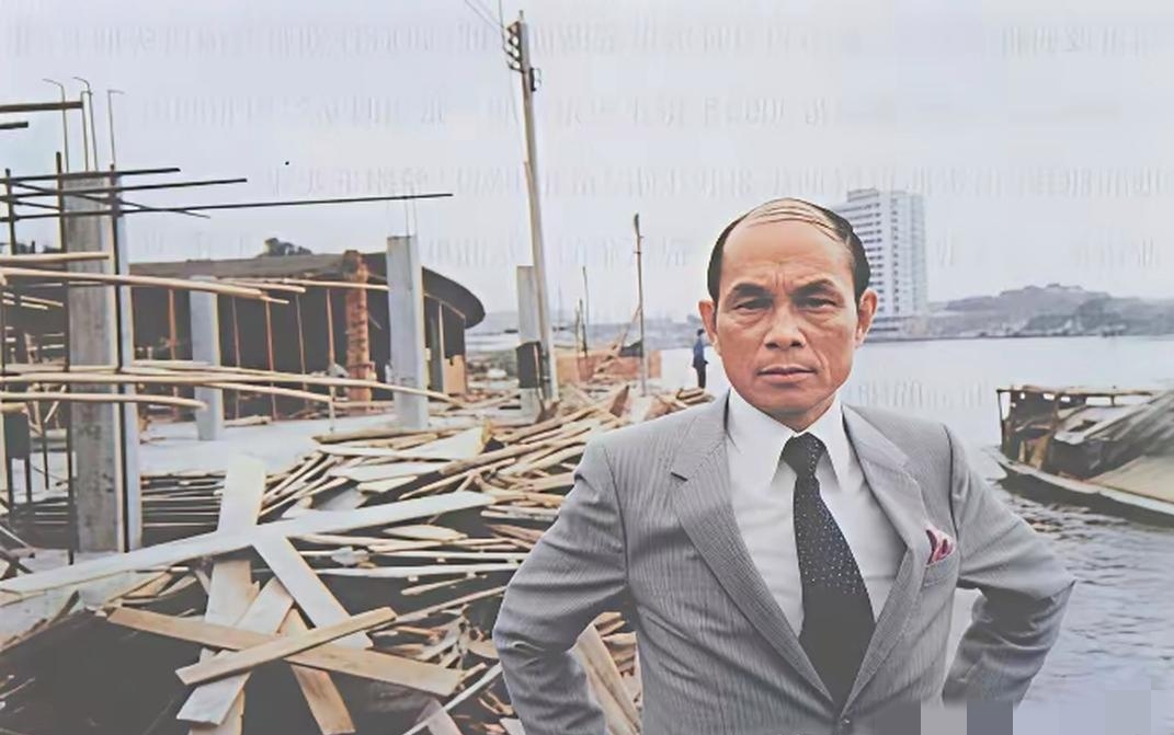80年代，霍英东正在自己投资建设的白天鹅宾馆项目工地上视察时的留影，身后是刚搭好的脚手架和堆放的建材，远处江面泊着木船，对岸的高楼还寥寥无几。