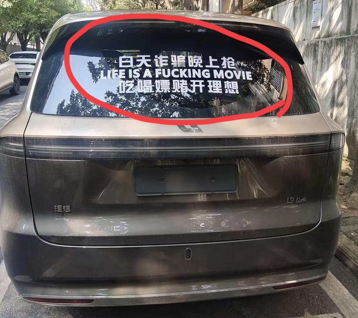 今天出门办事，路边看到这辆理想L9，后车窗那两排大字，简直是在挑战我三观！太没底线了！

“白天诈骗晚上抢，吃喝嫖赌开理想”，中间还加了一行英文，装文化人。

懂车的都知道，理想这车平时主打的是“奶爸神车”，主打一个顾家温馨。车主这波操作，显然是想靠着巨大反差来找点乐子。

其实他这是自黑，大街上老