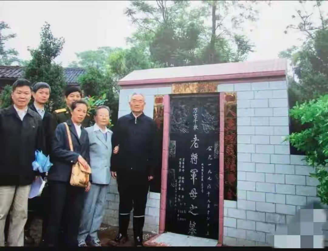 1999 年，已经离休的原成都军区政委万海峰将军（右一），携夫人赵政（右二）回到河南光山老家，在父母墓前与亲属一同留下合影。万海峰是开国大校，后晋升上将，历经抗日战争、解放战争，戎马一生。岁月晚年，将军重返故土，前来祭奠父母。墓前草木静静相伴，褪去一身戎务，此刻他只是归乡的游子。身旁家人齐聚，气氛肃