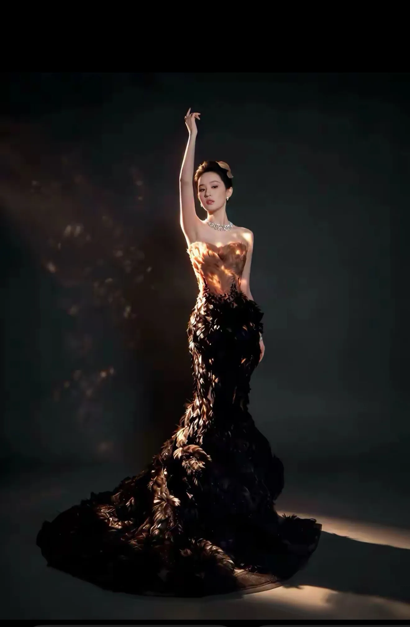 刘亦菲压轴VOGUE红毯：黑金羽衣一出场，“凤凰神女”有了画面

10月23日VOGUE盛典，刘亦菲压轴亮相。黑金羽毛高定层层叠叠，从裸粉过渡到墨黑，配复古盘发与珠宝，不靠轻盈仙气，却有一种沉静厚重的华丽。风一吹，羽片轻颤，网友说像“凤凰振翅”，“凤凰神女”也随之传开。这已是她连续第三年压轴，前有黄
