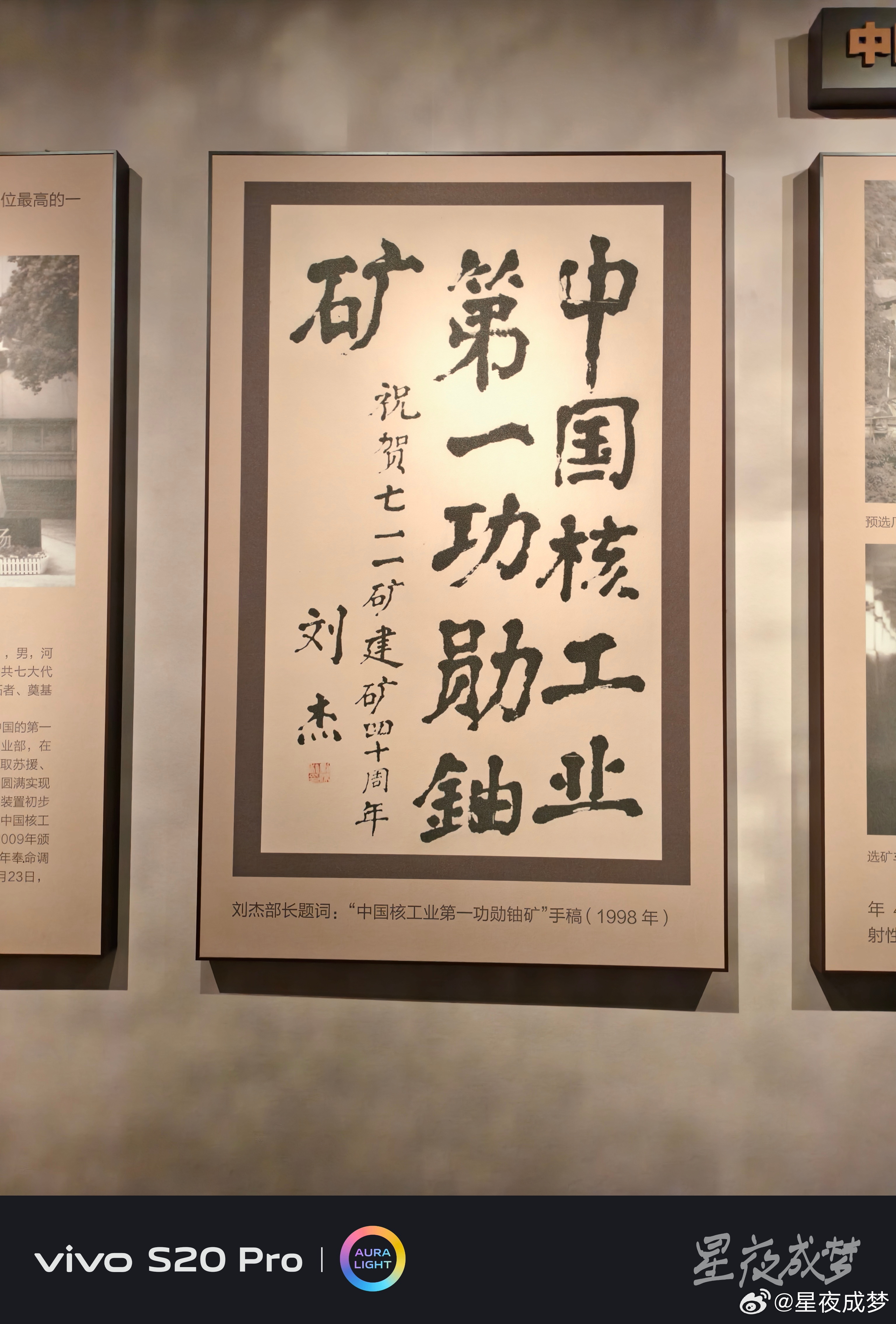 #vivo[超话]# 这幅刘杰部长的题词太有分量了，"中国核工业第一功勋铀矿"八个大字苍劲有力，是1998年祝贺七一一矿建矿四十周年的手稿，刘杰部长的签名和印章清晰可见，这不仅是一幅书法，更是对七一一矿历史地位的最高肯定。用vivo S20 Pro拍下这幅题词，毛笔字的笔触和印章的细节都清晰锐利，色彩还原 ​