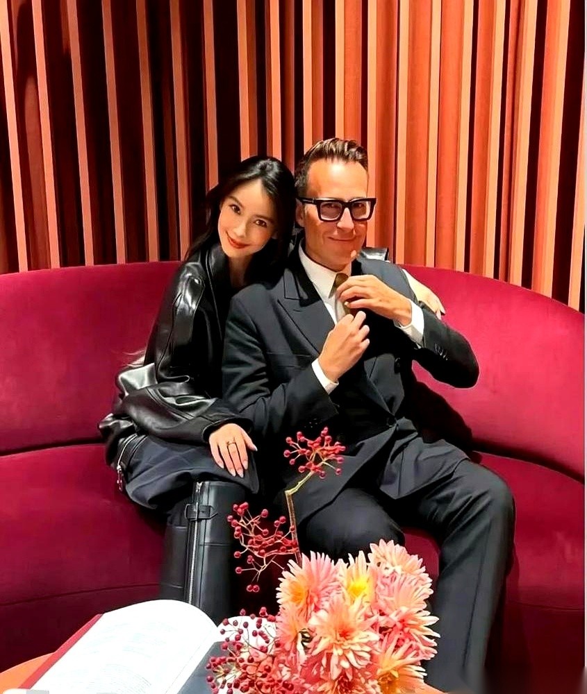 刚流出的巴黎时装周生图里，杨颖和爱马仕公关总监Michael Coste同了个框。
在这个走错半步都要被扒皮的顶奢名利场，别人跟高管合影都是双手叠放、笑得规规矩矩。她倒好，右手直接越过去，实打实地搂在了这位爱马仕实权人物的肩膀上。
没有刻意找打光，也没有紧绷着摆什么红毯定海神针的造型，她身体自然地往