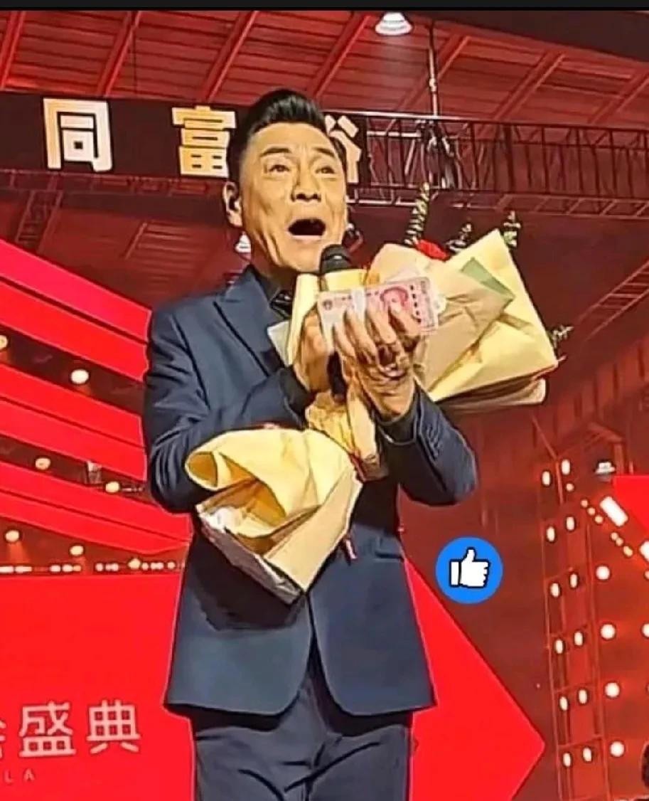 2026年2月13日，河南矿山起重机有限公司办年会。台上站着屠洪刚，唱了《霸王别姬》《江山无限》《精忠报国》三首。台下坐着七千名员工，桌上堆着六千万现金。老板崔培军现场发钱，全年发了1.8亿，被人叫“全网最爱发钱老板”。
唱完歌，崔培军塞给屠洪刚一个红包，两万块现金。按理说，一个出力一个给钱，收下就