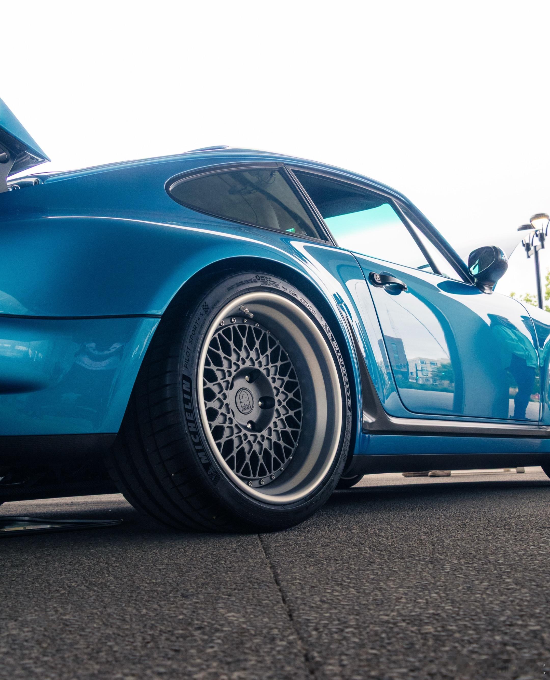 复刻八十年代涡轮猛兽的经典姿态，保时捷911 930 Turbo 换装 HRE Vintage 501 锻造轮毂，完成复古与性能的完美契合。作为专为经典性能跑车打造的复古系列轮毂，HRE 501 标志性的多辐网孔造型搭配宽抛光外唇，精准适配930宽体车身比例，完美填满原车宽硕轮拱，复刻原厂经典赛车氛围。
整车采用前后配专 ​