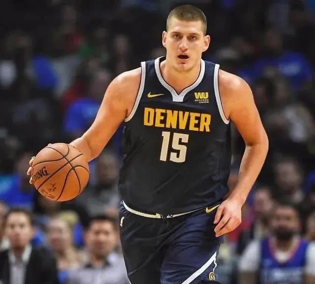这个问题问了快十年了。2014年NBA选秀大会，掘金在二轮第41顺位念出约基奇名字的时候，电视画面里播的是一条卷饼广告。他本人在塞尔维亚家里睡觉，醒来才知道自己被选中了。同一年，一份球探报告白纸黑字写着他缺乏速度和弹跳能力，很难留在NBA。这份报告后来被前NBA主帅乔治·卡尔翻出来转发，时间是202
