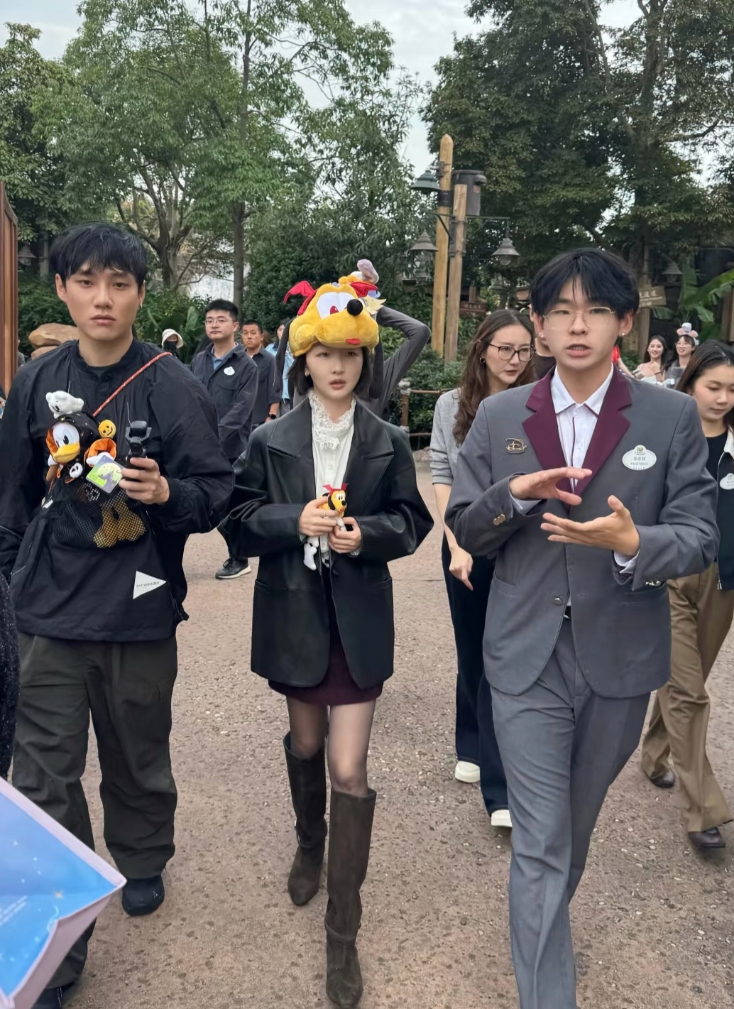 34岁周冬雨在上海迪士尼乐园游玩被偶遇，她身穿白色花边领衬衫，外穿宽松黑色皮西装搭配酒红色短裙、黑丝与深棕色高筒长靴，增添了柔和的少女气，随性又很有时尚感，皮肤白皙，身形纤瘦，脸比镜头里还要小巧，整个人状态放松随性，完全没有刻意营业的紧绷感，像放假出来游玩的大学生，充满鲜活的灵气。