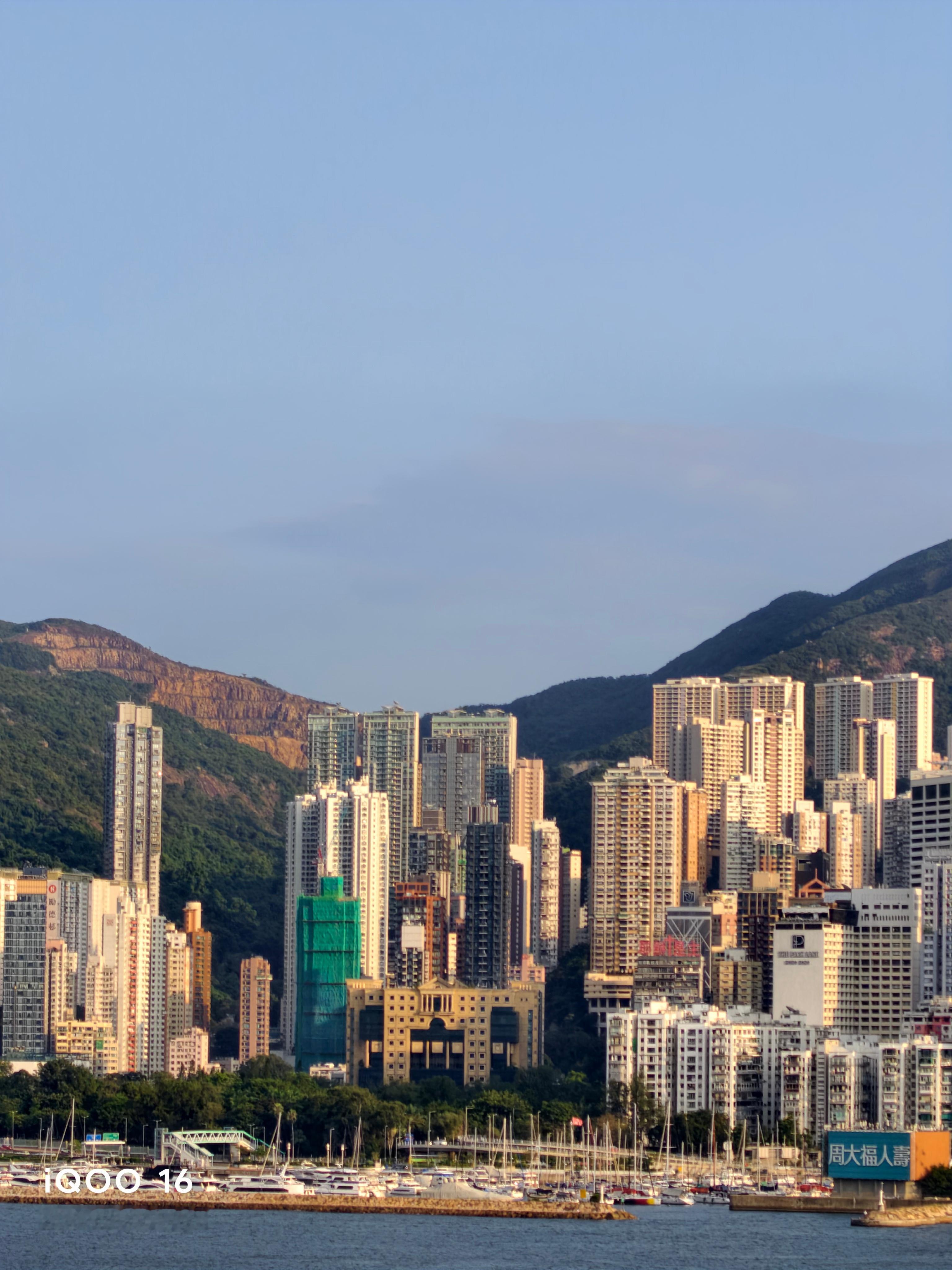这次香港出行全程拿#iQOO16# 拍照，先说人像模式，我之前还担心旅游拍人会很假，结果完全不会。不会疯狂磨皮把人脸糊得没细节，风吹乱的发丝也能抠得很干净。拍人像也不会无脑把背景全部虚化掉！像维港这种好看的城市风景，人和景色可以同时保留。

夜景更是超出预期！香港这种灯超多的地方，高楼密密 ​