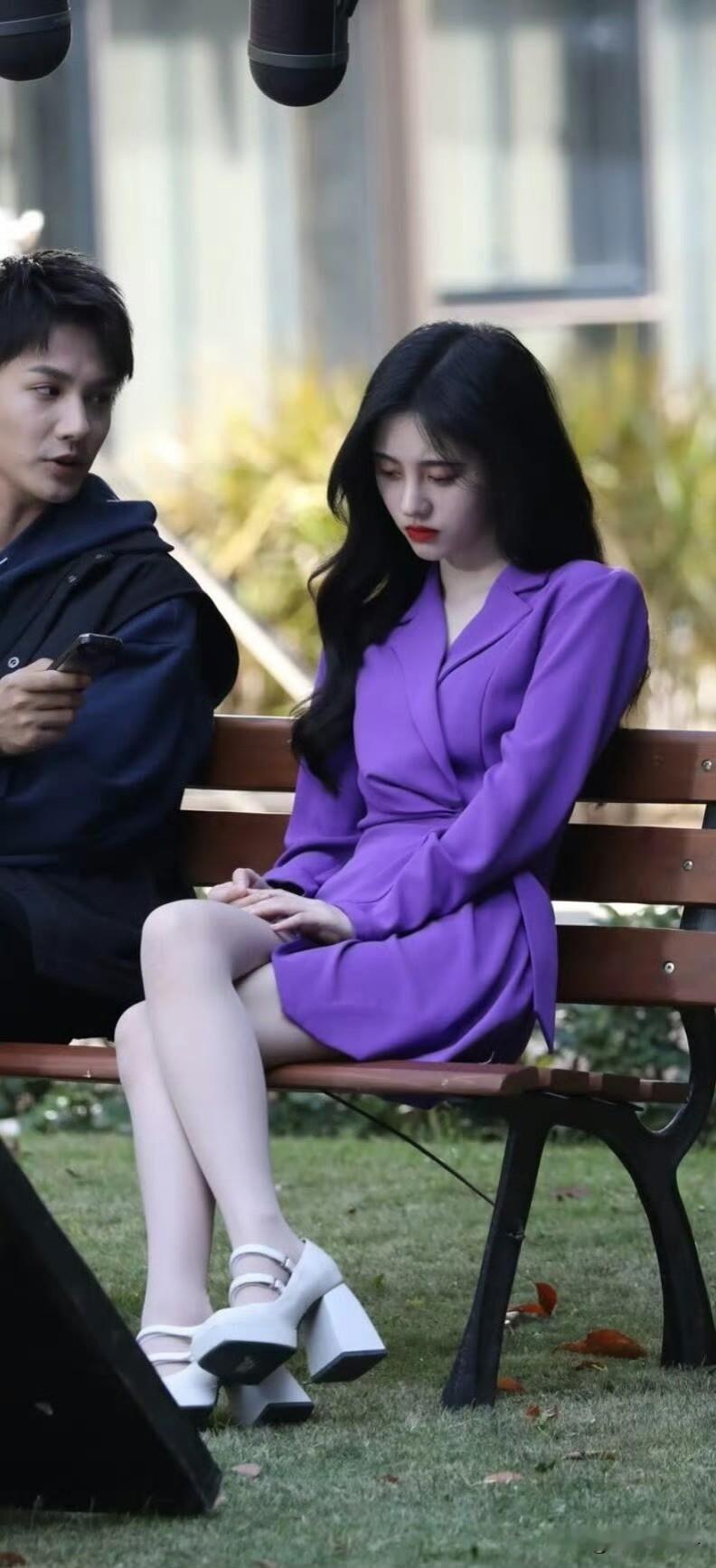 鞠婧祎、郑业成《满月之下请相爱》片场路透。
鞠婧祎穿紫色西装款短裙，搭配肉色丝袜和白色粗跟玛丽珍鞋，长卷发，这套是剧中雷初夏的造型。还挺港风！