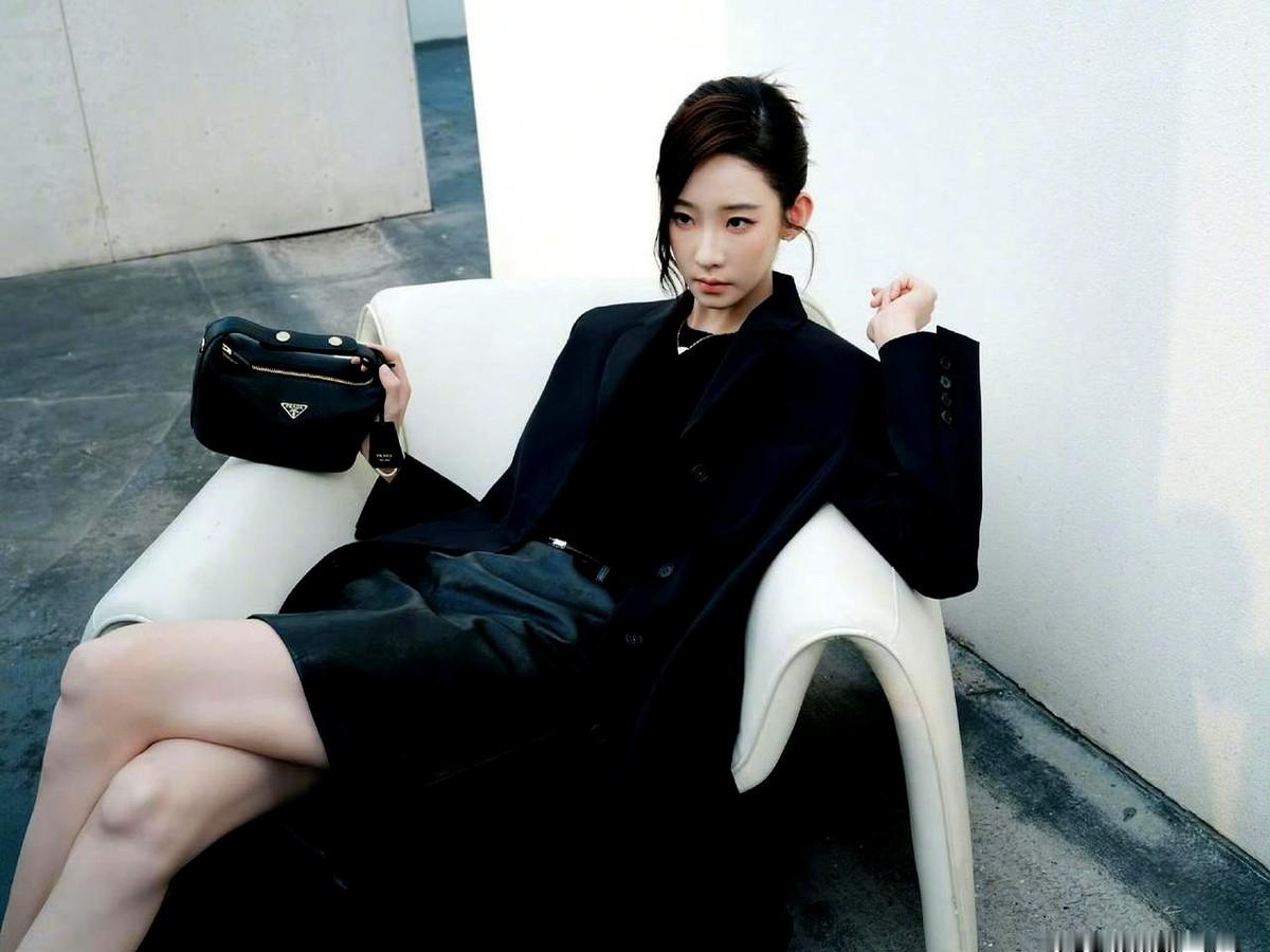 张艺凡居然穿上了2026年的普拉达，这资源，不简单。

她一身全黑，无袖针织衫配皮裙，挎着个同色手袋，脖子上的金饰亮得晃眼。这身行头，说是假日系列，但看着就是一股子冷清劲儿。

有人说她气质和这牌子太搭了，都是那种淡淡的、不爱说话的感觉。从年初的荣宅活动，到七夕的大片，再到这次，她跟普拉达的合作就没