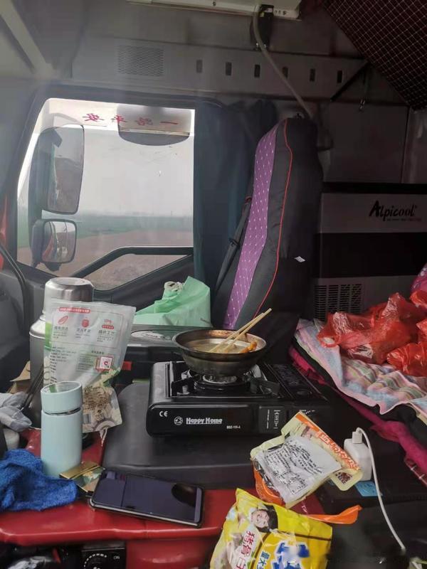 在高速服务区，看到一个山东牌照的货车司机，在车边用酒精炉煮水泡面。俺问他咋不去餐厅，他说“一碗面二十块，俺自己泡才三块，省点给孩子买书”。他拿出两个馒头，一包榨菜，就着泡面吃得香。俺心里酸酸的，山东男人，上有老下有小，啥苦都能吃，啥罪都能受。#货车司机为啥都夸广西服务区# ​