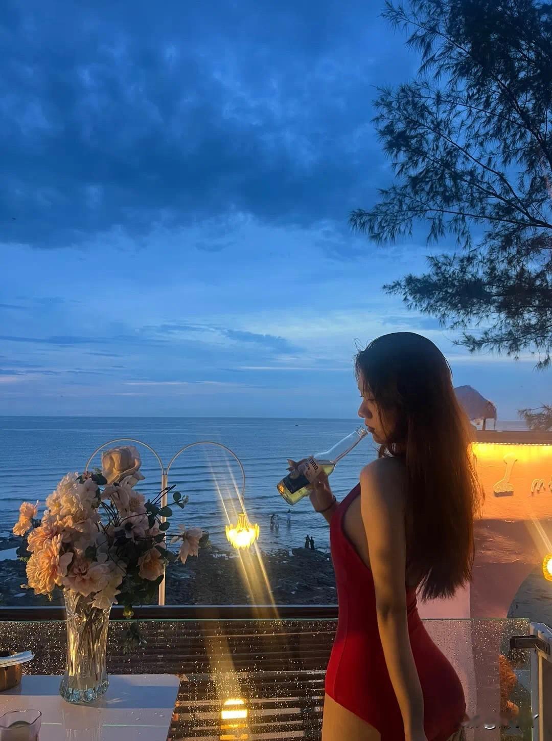 夜幕海边，邂逅红裙微醺浪漫  暮色漫上海岸，晚风轻拂，穿红泳衣的小姐姐...