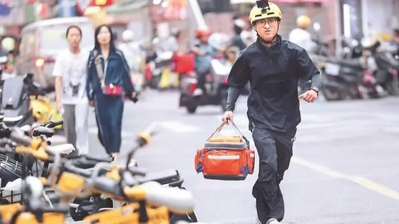 南京这个00后外卖员罗鑫明，有人刷到视频先皱眉：车贴AED、后背急救包、跪地按压，是不是人设？我把几份通报和蹲点稿翻完，结论很直接——这人不像作秀，而且该多讲。
他2004年、江西吉安人，2024年前后到南京跑专送，一天30—50单。2025年底考红十字救护证，去年12月底进“一键救护”先锋队，手机接120联动派单，电动车后箱常备外伤包、可塑形夹板、血压血氧仪、常用药、氧气罐、AED贴片，早期全自费，包从手掌大加到30多斤，前后几千块；今年7月南京红会又把一台实体AED放他车上。
次数别只记一个号，免得被挑。南京日报9月28写“9个月507次、150多小时”； 南京红会9月9写一键救护481次、142小时； 网易引他自述从去年12月26日起501次、151小时。 差别是统计截止日和是否只算一键救护，合起来就说“整体约500次量级”最稳，里面不全是心脏骤停，也有摔伤、骨折、崴脚、车祸、老人倒地。
真案例一摆，摆拍论就站不住。2月20日南图门口外地游客心脏骤停，他手头5单未送，5分钟到...