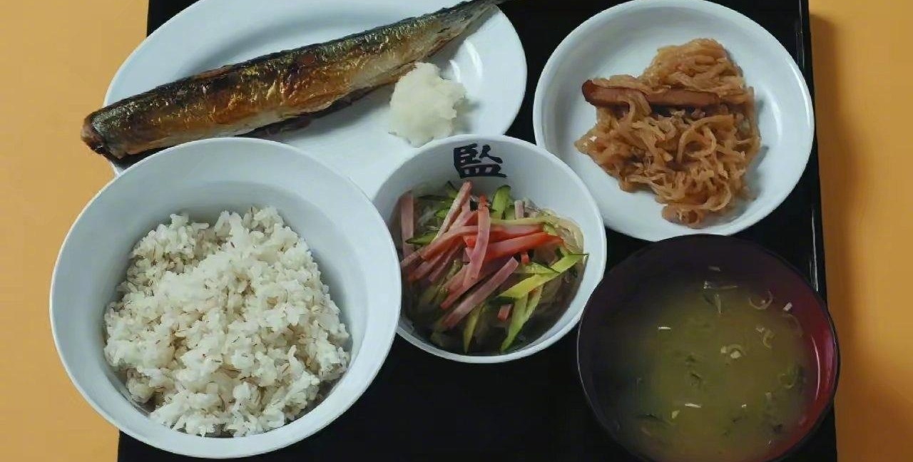 刷到日本监狱伙食那组图，我第一反应是：这饭看着比我上班带的盒饭还认真？

再往下看，日本小学伙食、日本议员伙食、日本名古屋亚运会伙食，全被拉出来对比。米饭、鱼、牛奶盒、小菜，摆得整整齐齐，看着挺像那么回事。

可越看越无语。监狱餐、学校餐、会议餐、赛事餐，明明都是吃口饭，愣是被网友玩成了“伙食大比拼
