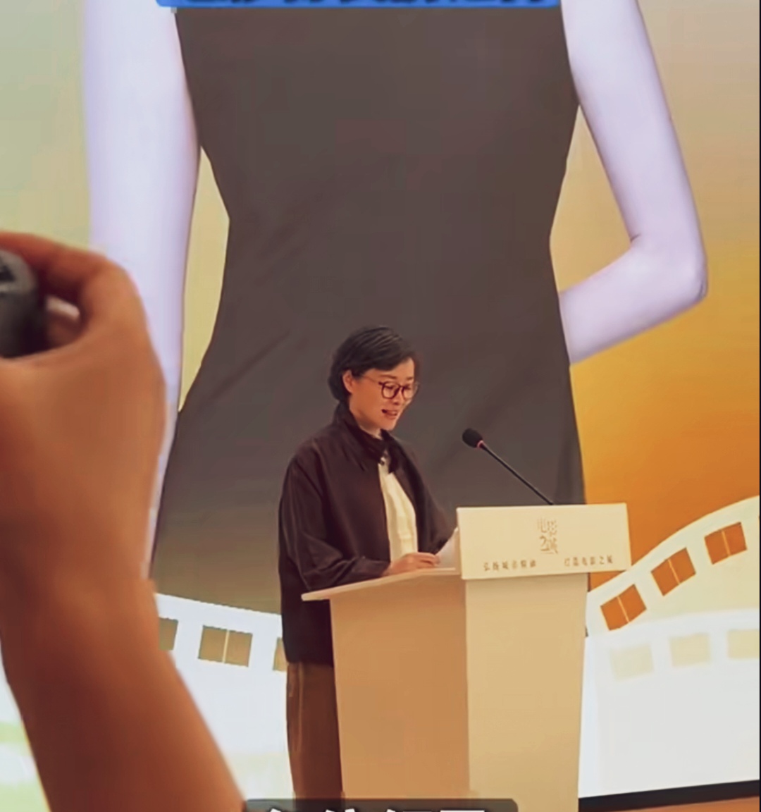 吴越线下论坛发言现场。利落短发，一副红框眼镜，低调素雅的穿搭，捧着稿件娓娓道来，气质沉静温润，知性气质太出圈。