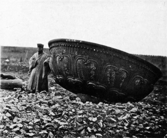 1871 年，一名男子与一块青铜圆顶碎片合影，这张照片生动地记录了南京宝陵塔的悲