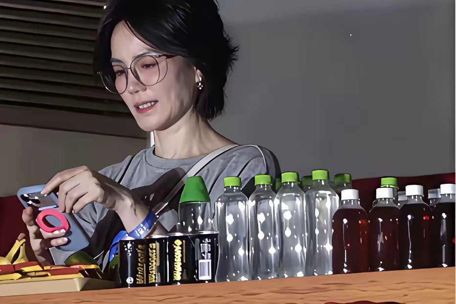 出席活动的王菲提前把矿泉水瓶上的商标全部撕掉了。 ​