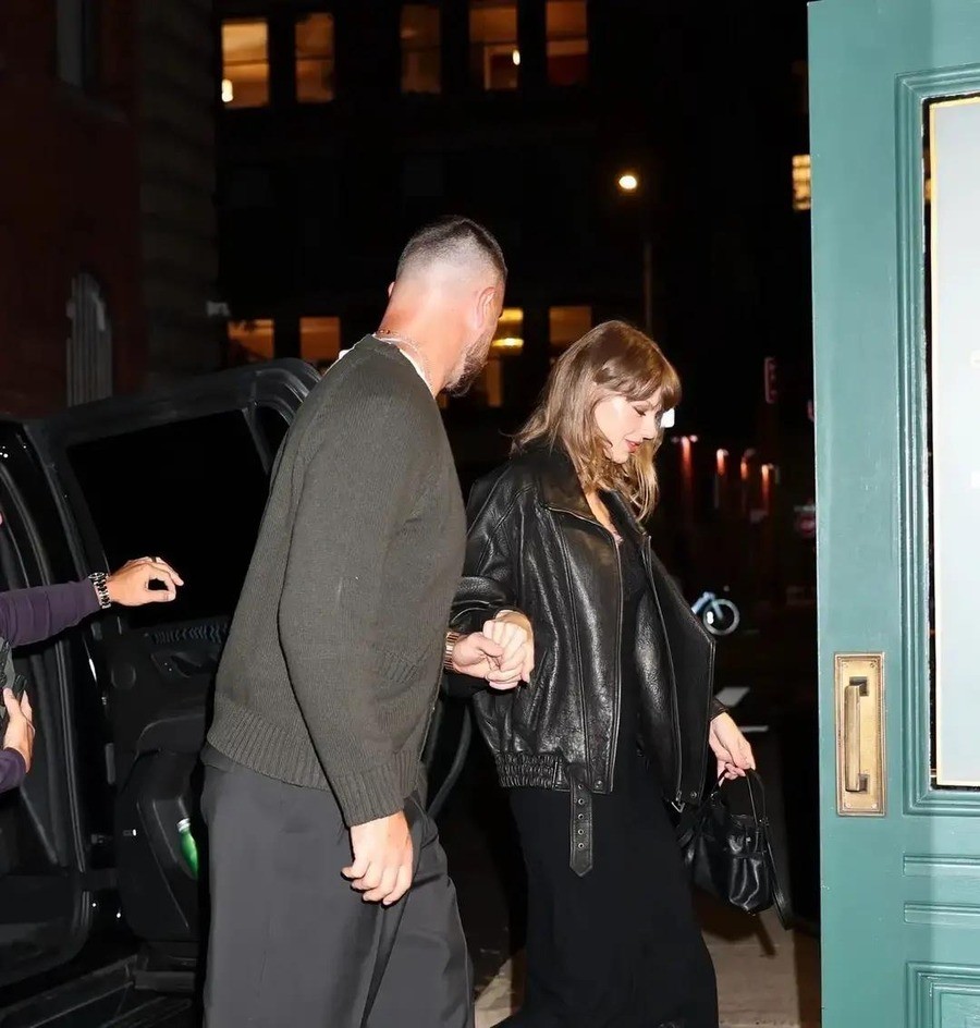 Travis Kelce 37岁生日，他老婆Taylor Swift带他去纽约SoHo的Torrisi餐厅吃了一顿意大利菜，没有包场，没有红毯，全网传的是他脚上那双带跟的黑皮鞋。
这双鞋被人笑了三天。
Page Six写了，他穿了一条宽松阔腿裤配带跟靴子，给他一米九六的身高又加了点高度。Celebi