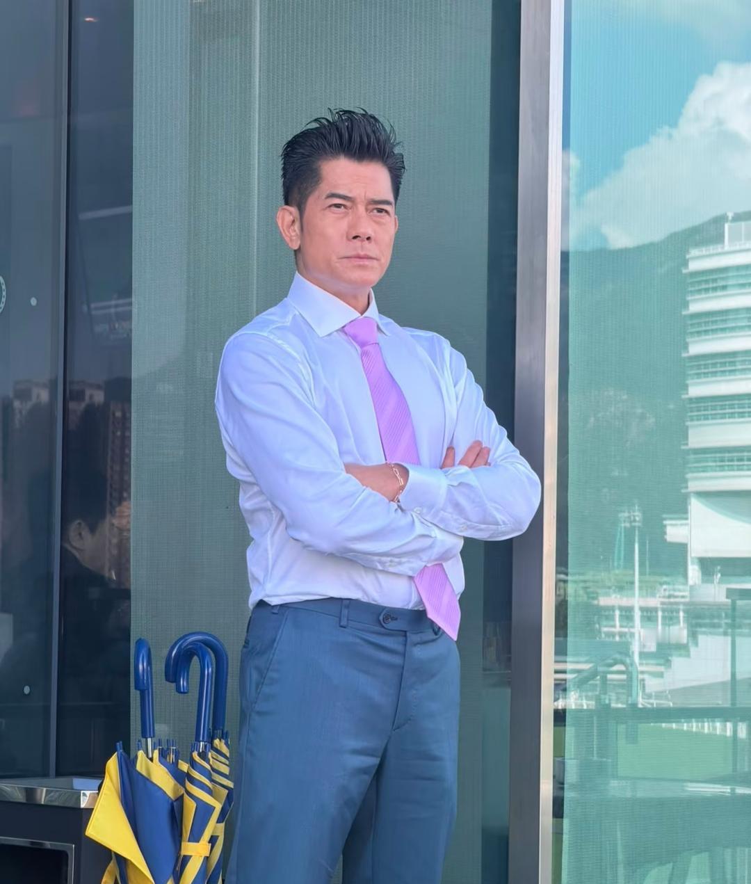 61岁郭富城现身香港马场看赛马，他穿着一身西服，搭配粉紫色领带，展现出经典的“老钱风”与绅士风度，举手投足间尽显成熟男性的稳重与高级质感。发型打理得油光锃亮，细节处彰显对形象的极致追求。身形挺拔，气质一直在线，老得很有分量，整个人精气神十足。他的状态太好了，头发又黑又多，看起来好年轻。