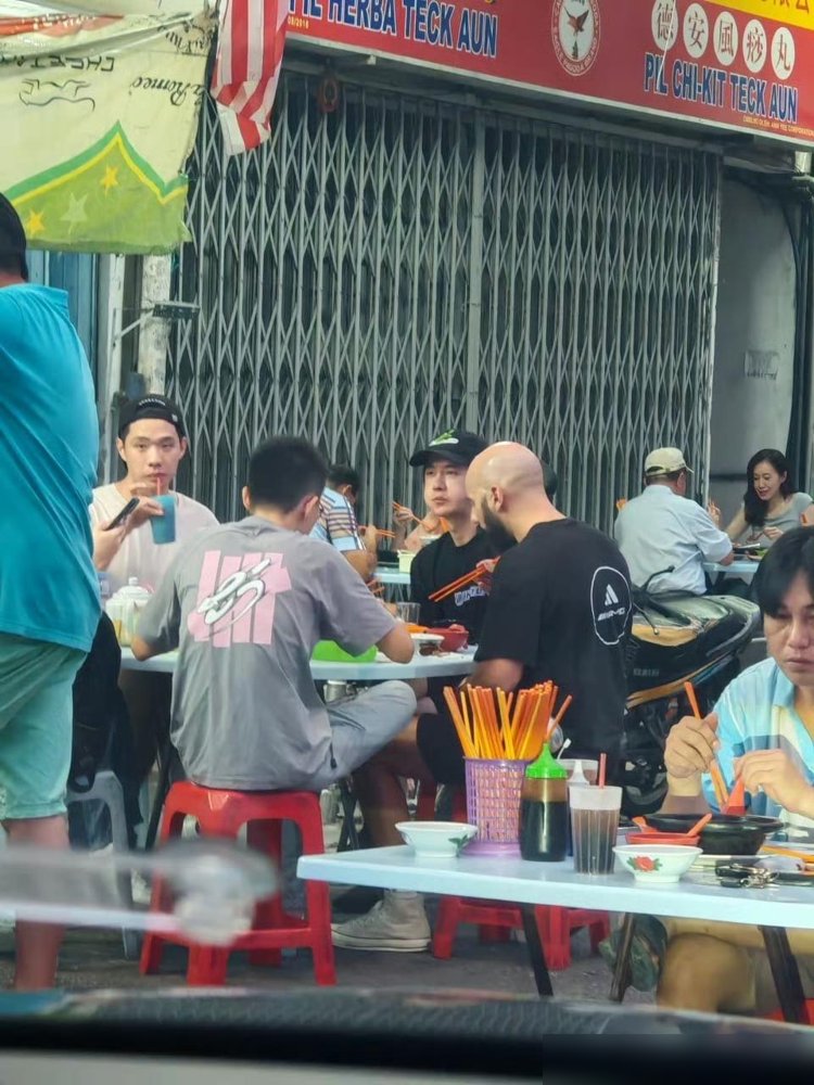 王一博蹲在马来西亚路边摊啃串儿，旁边坐着UNO车队那帮老外，没保镖没助理。
85号赛车手这次是玩真的。10月11号就飞吉隆坡了，天天泡在雪邦赛道高强度试车。11月6号到8号，China GT年度总决赛，人家职业生涯头一回跑海外赛道，也是这赛事头一回搬出中国办。
你看他穿个大裤衩人字拖，跟车队技师