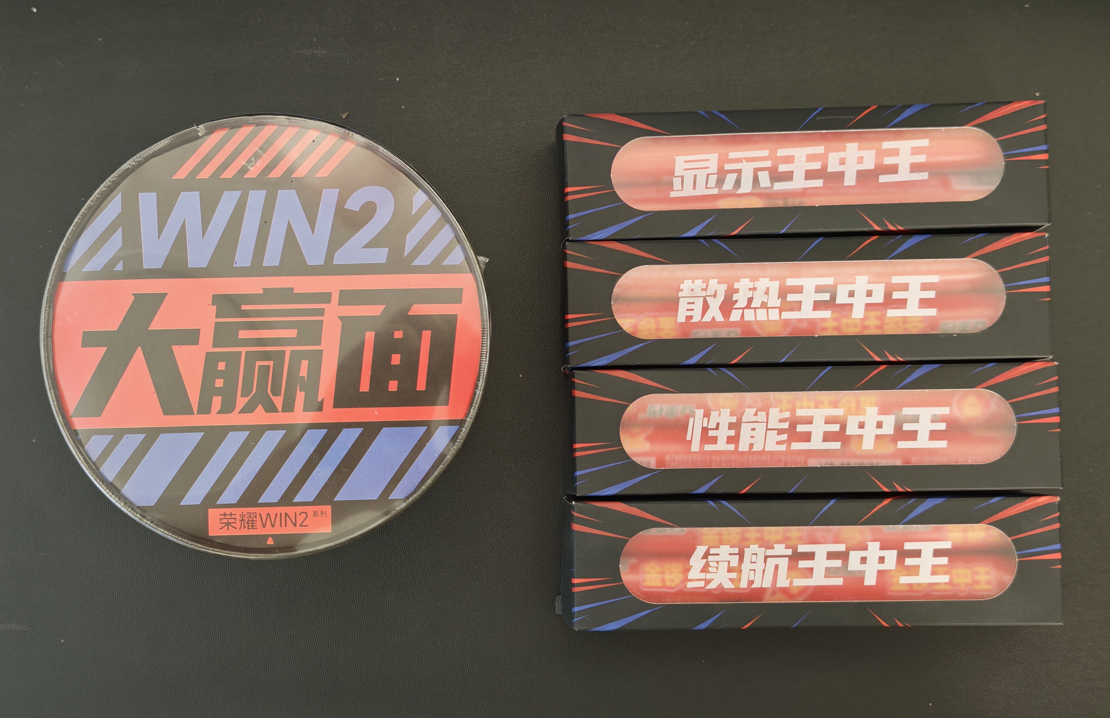荣耀WIN2的发布会邀请函挺有意思的，这一次是火腿肠+泡面，简称“场面赢”！王中王的火腿肠更是分了性能、散热、显示、续航四个盒子，代表了这一代WIN2系列的全能表现。记得上一代WIN的发布会邀请函是锅巴，这一次WIN2是代表“场面赢”的火腿肠+泡面，不得不说，荣耀WIN系列的宣发人员，绝对都是年轻人